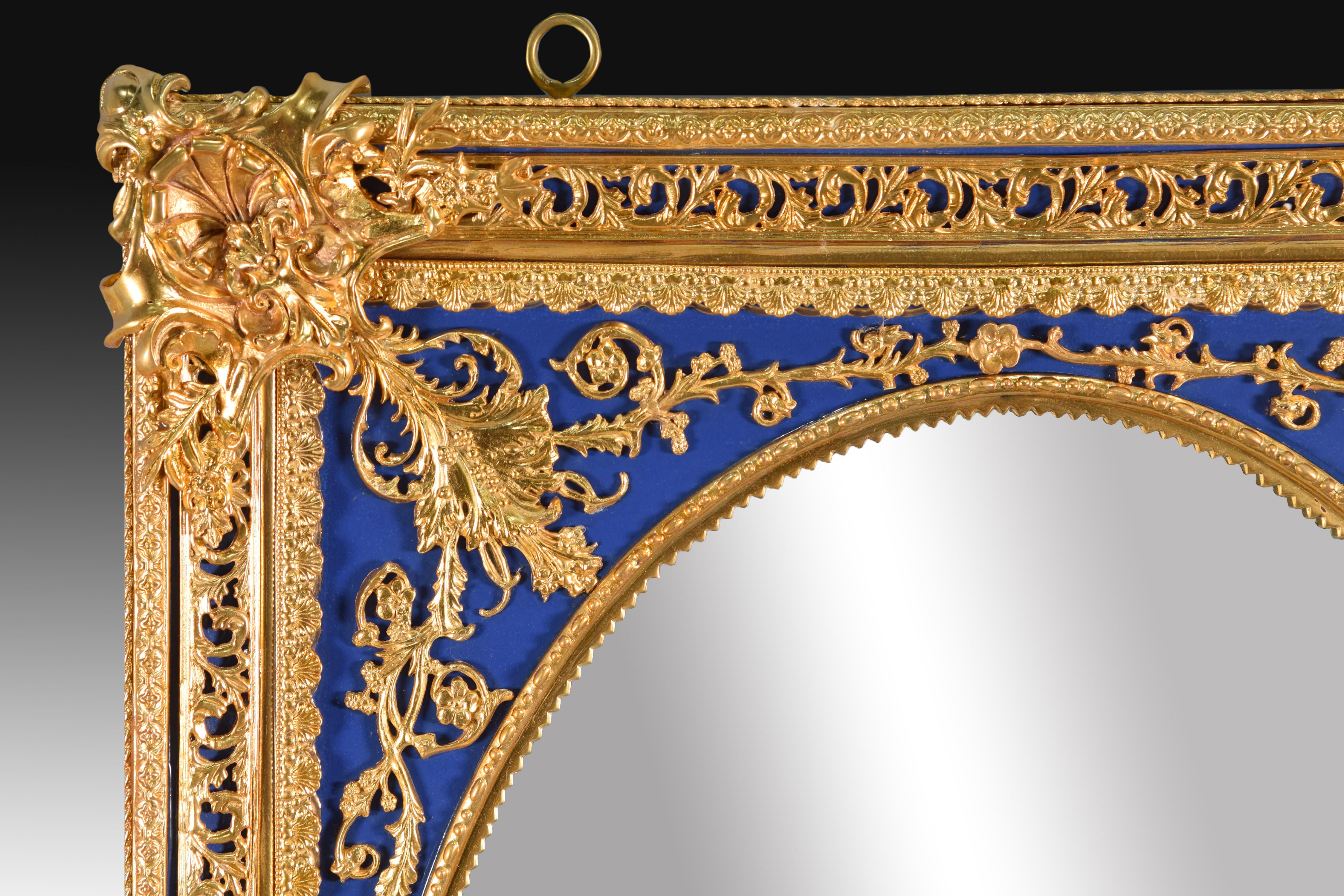 Mirror. Porcelain. 
 Mirror frame made of porcelain and decorated with elements of clear neoclassical inspiration in gold (vegetable, architectural, etc.) on a blue background, following the usual models in the main European porcelain factories of