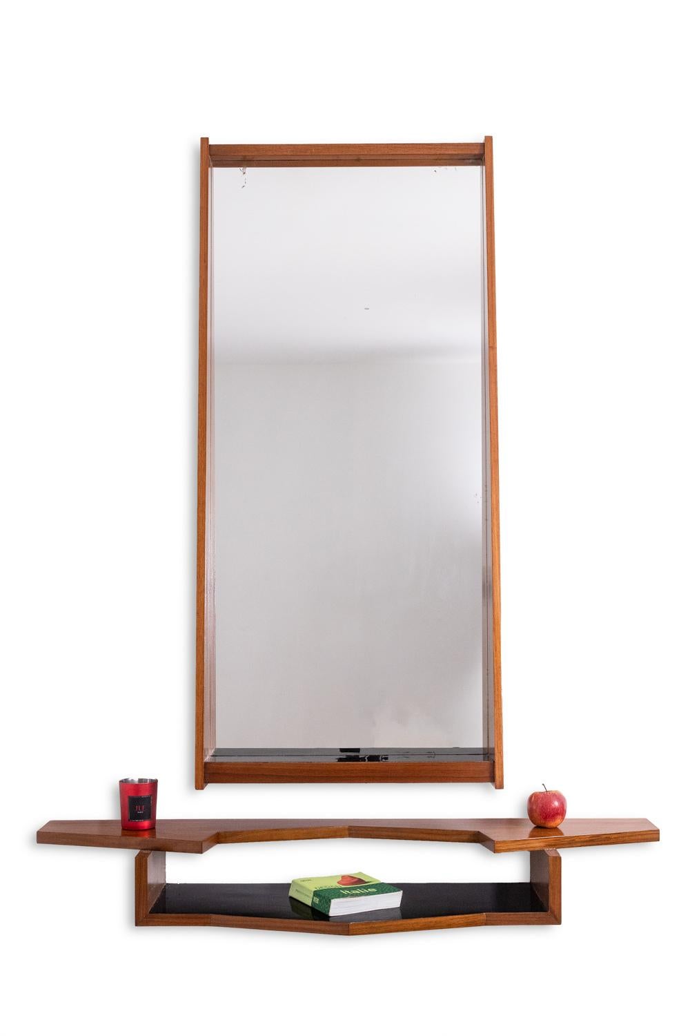 Specchio da parete e console in mogano, la console con due ripiani asimmetrici, quello inferiore rivestito in laminato nero.

Opera italiana realizzata negli anni '1970.

Dimensioni:

Miroir : H. 132 x L. 60 x P. 13 cm

Console : H. H. 16 x L. 120,5