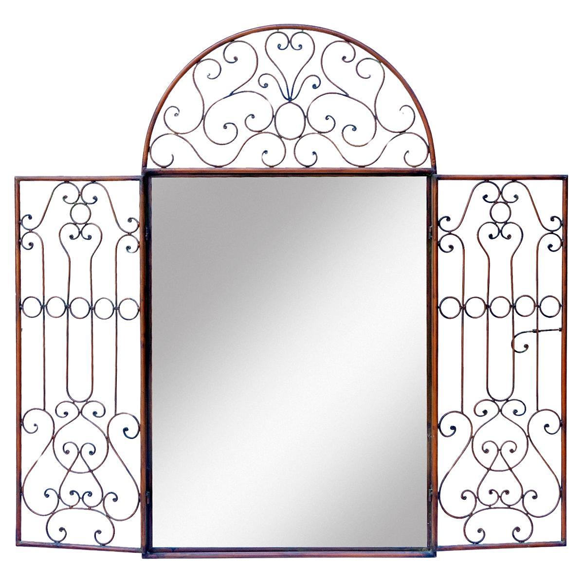 Stunning wrought iron frame mirror that features scroll detail. The doors secure shut with a latch. When the doors open a full view of the mirror is revealed.
