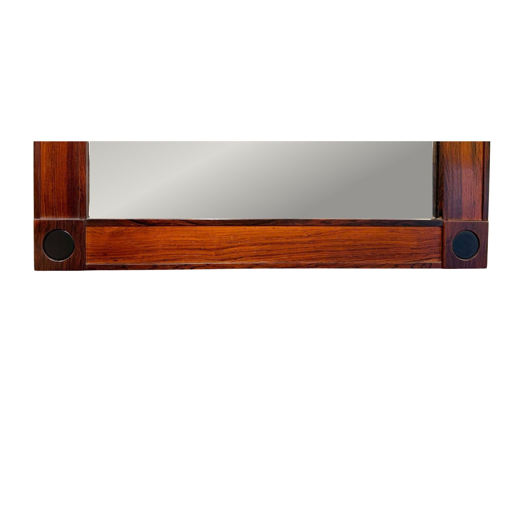 Beautiful mirror in rosewood and leather by designers Alf Svensson and Ingvar Sandström. The frame is made of rosewood with a lovely structure featuring a worked rectangular pattern, which gives it its uniqueness, along with round black leather