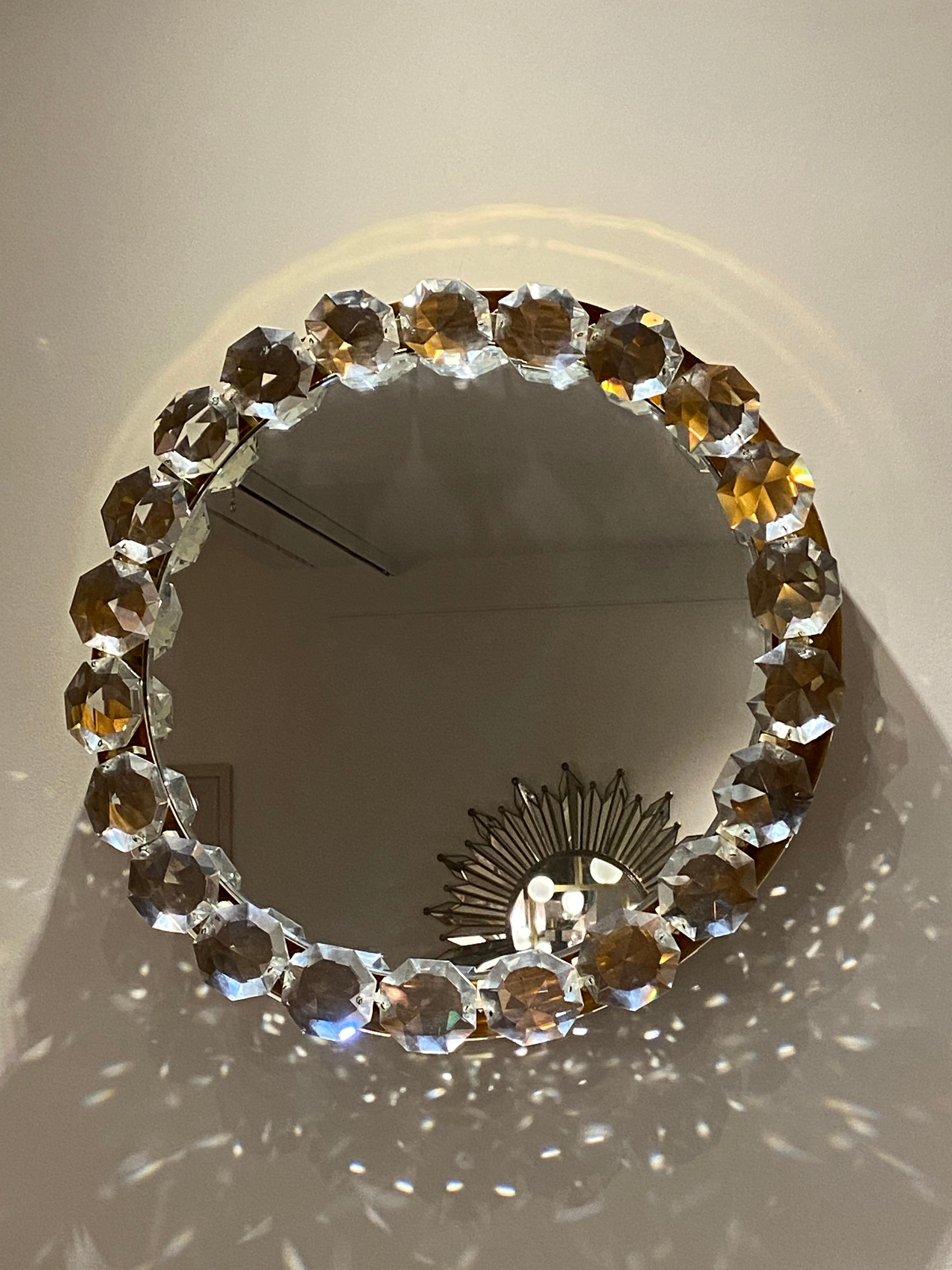 Circular chromium-plated mirror, framed by large hand-cut glass crystals. It could be illuminated, though it is not currently electrified.

