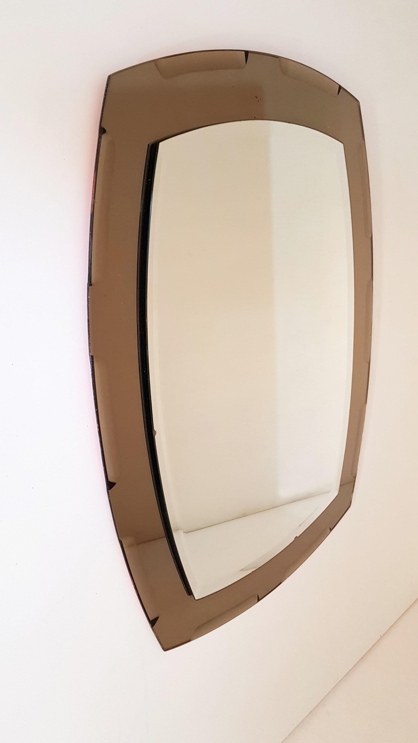 Vintage Italian, all glass mirror by crystal Lupi Luxor (Antonio Lupi). The main bevelled glass plate is mounted on to an oval smoked, silvery colored glass frame, which in some lights looks a silvery beige.

 