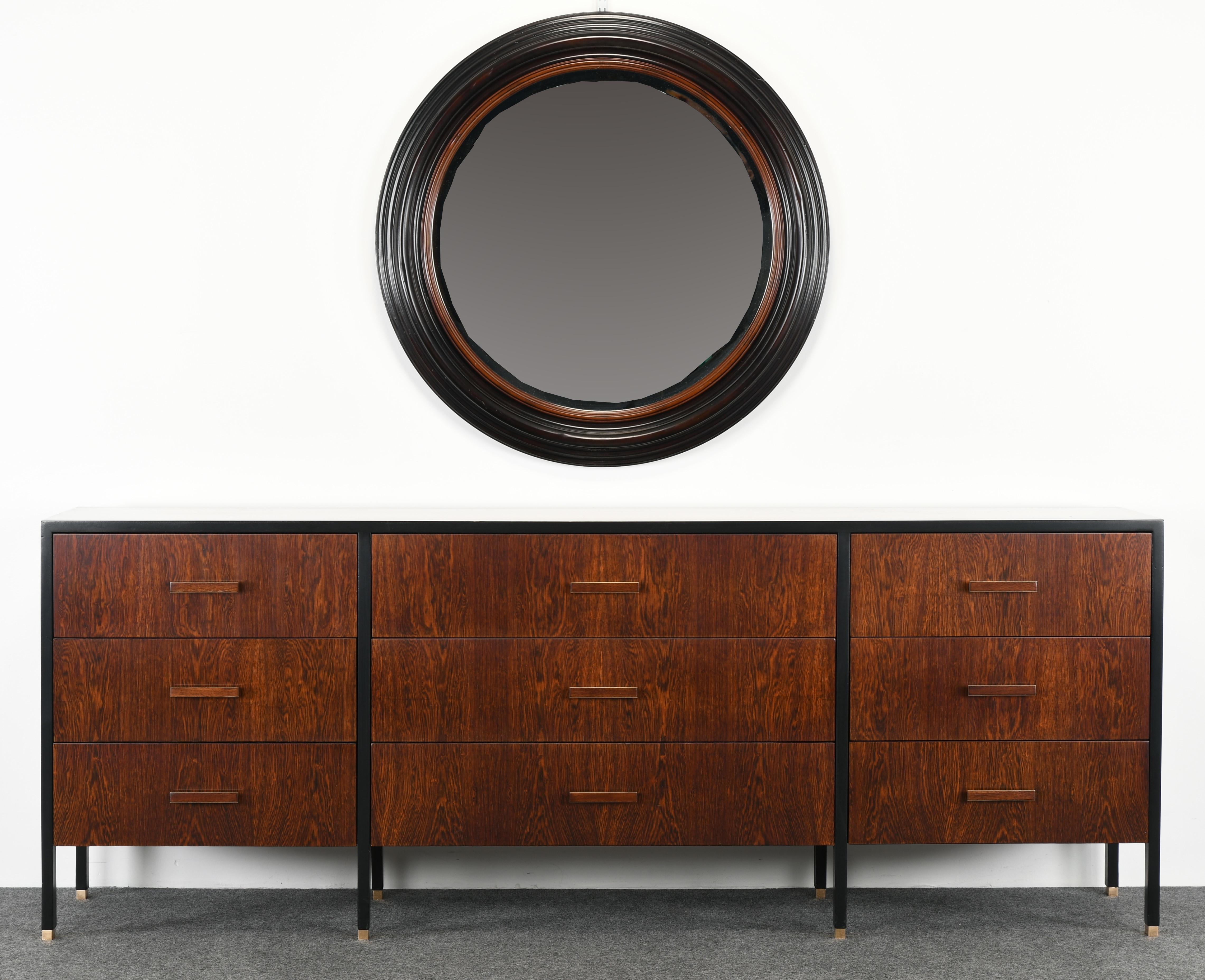 A stunning round ebonized maple wood mirror with natural wood accent and beveled glass. This mirror would look great in a modern or antique setting. Labeled 