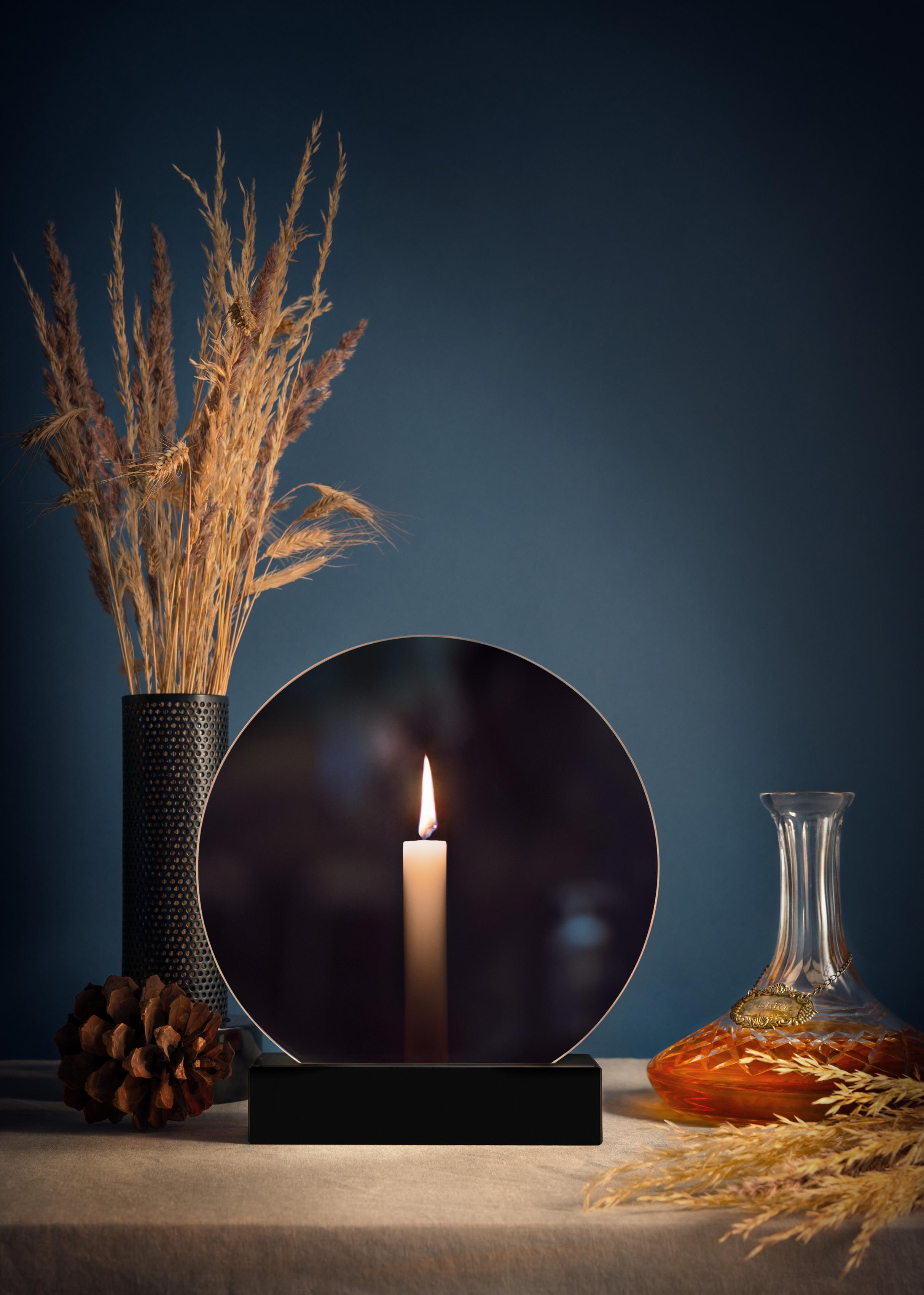 The two-sided Spegla is an interior object that works both as a mirror and a candle holder. The circular glass sheet reflects the light of the room when the candle isn’t lit. While the candle is burning, the glass sheet transmits the light through