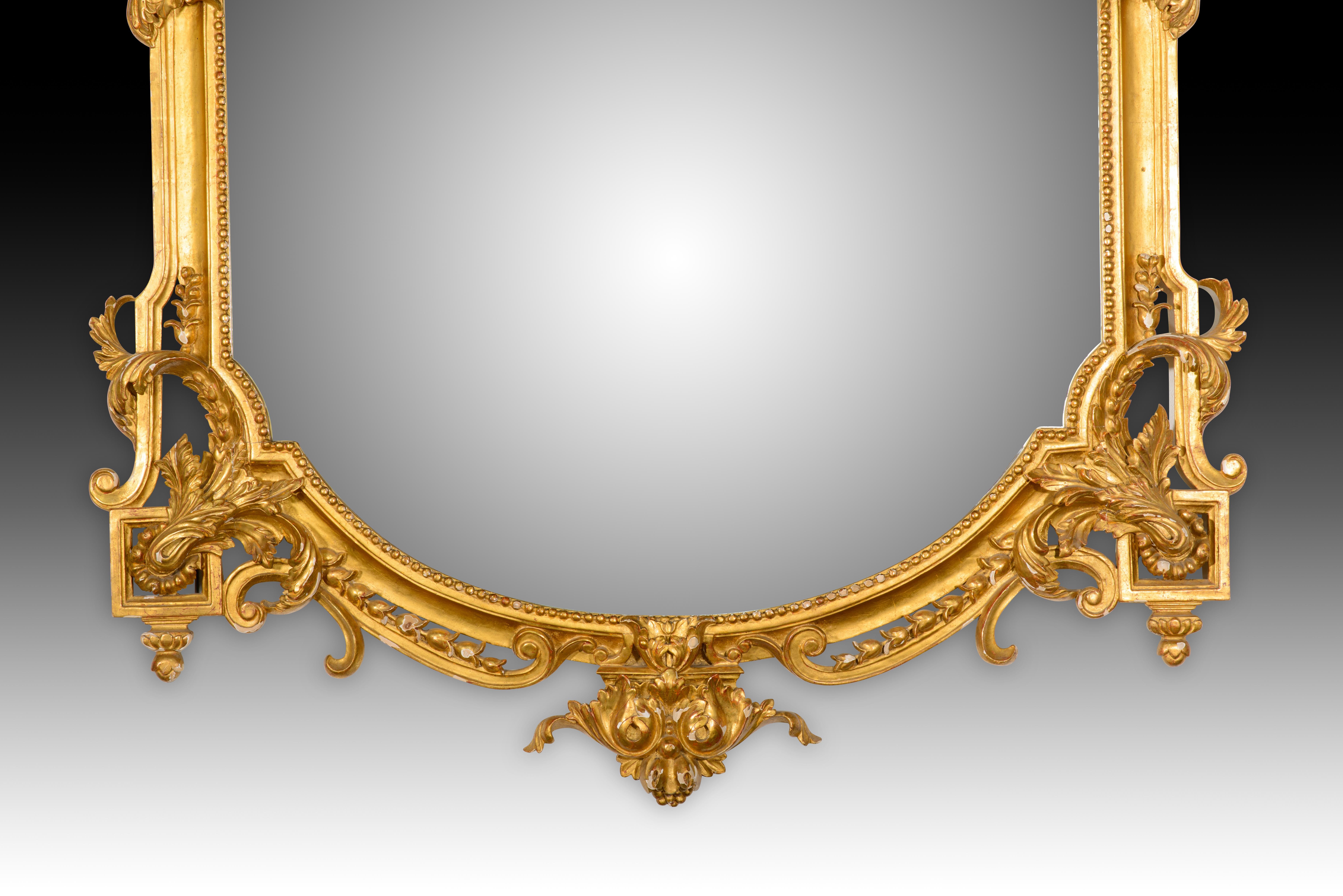  Specchio. Madre intagliata e dorata. XX secolo. 
Grande specchio con cornice in legno intagliato e dorato, decorato con una serie di elementi decorativi di ispirazione classicista che ricordano le influenze francesi del XIX secolo. Alcuni dettagli