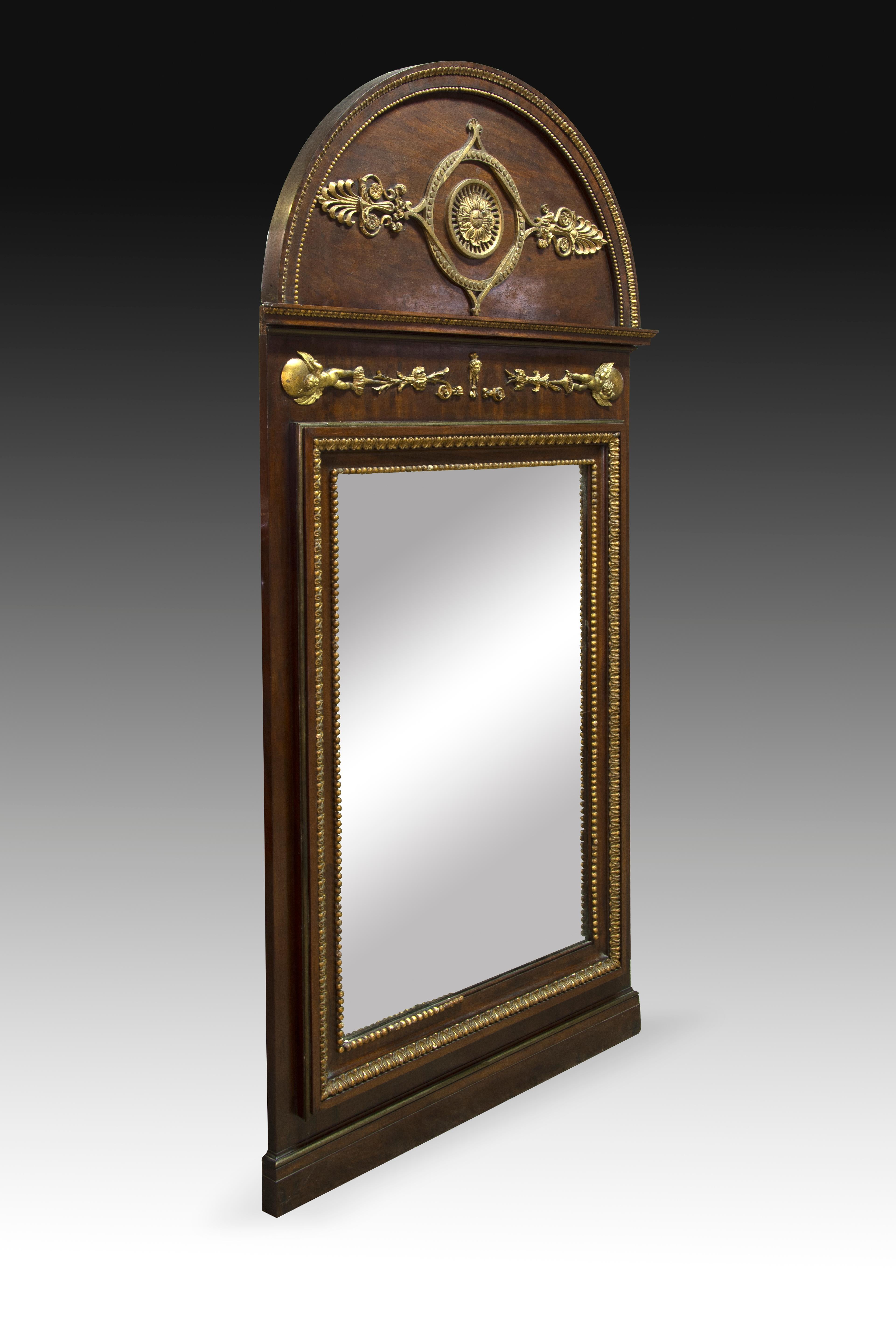 Miroir Fernando VII. Bois sculpté et doré, verre. Vers le début du 19ème siècle.
Miroir rectangulaire en bois sculpté dans sa couleur, se combinant avec des décorations de forte influence classique en bois sculpté et doré, rappelant les appliques en