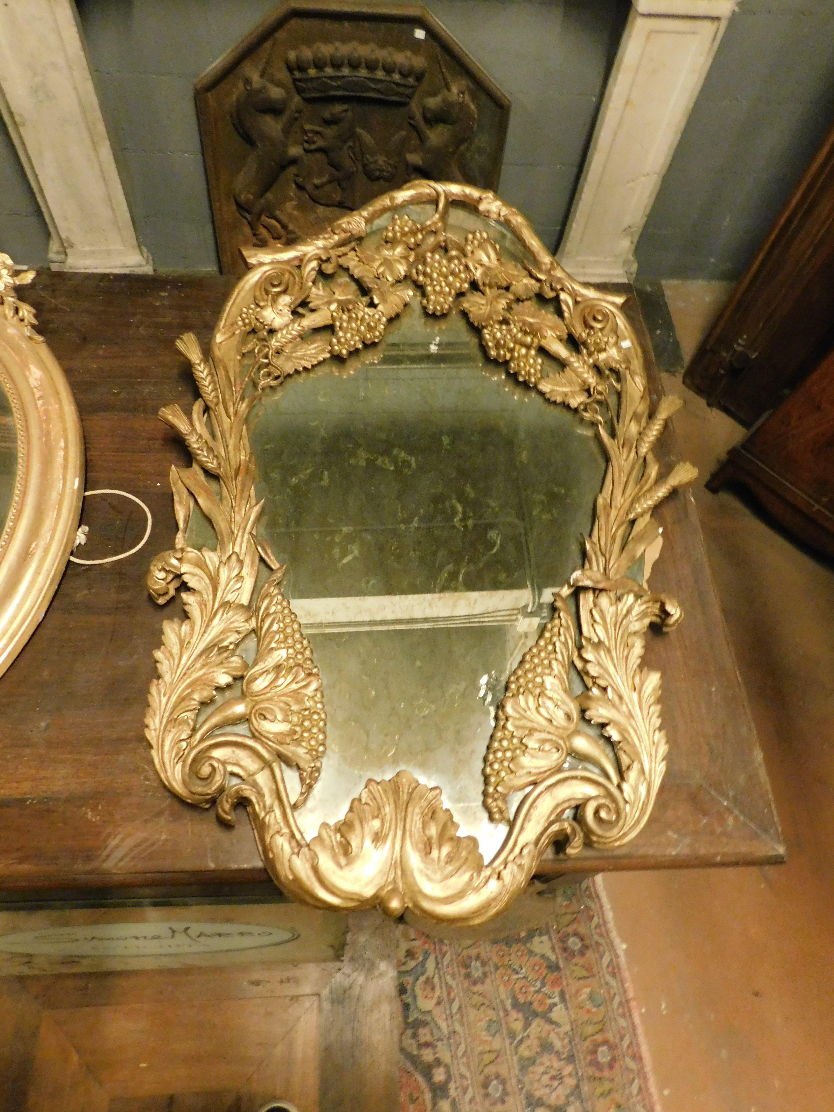 Ancient mirror richly carved by hand, with floral decorations and grapes, gilded, built in the 19th century in Italy.
Thanks to its richness of shape and good size, it can be easily adapted to all interiors: bathrooms, living rooms, halls, above