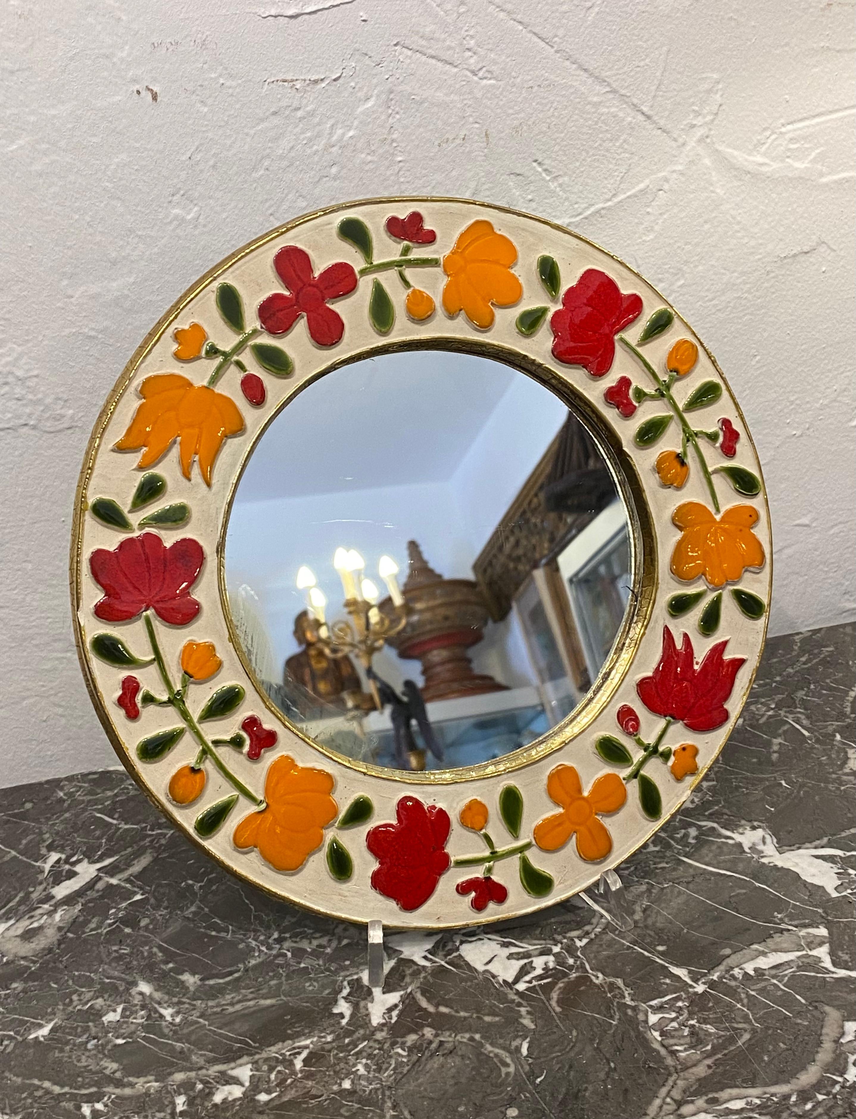 Ceramic mirror by the artist Mithé Espelt* Circular in shape decorated with orange and red flowers on a white background, richly gilded on the towers. Romantic range, presented in the book 