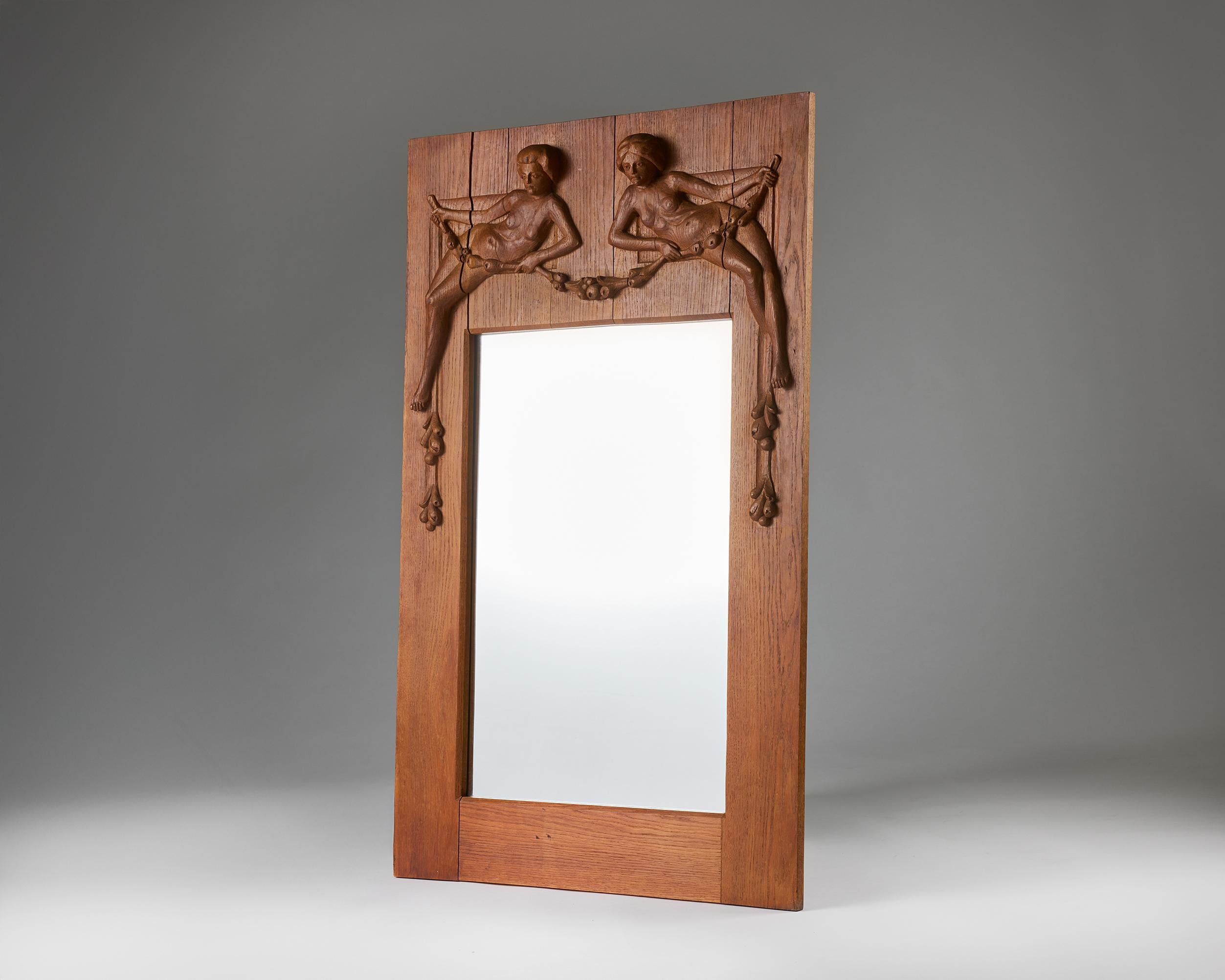 This rare and elegant Swedish Art Deco mirror, designed by A. Bergström in the 1930s, embodies the elegance and craftsmanship characteristic of Scandinavian design. At the top, the solid oak frame is exquisitely hand-carved with two nude figures