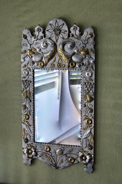 Mirror featuring two-tone repoussé metal pieces on a wooden backing