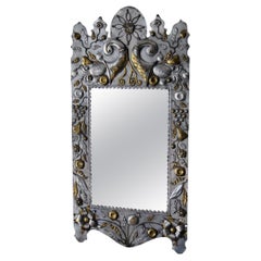 Mirror featuring two-tone repoussé metal pieces on a wooden backing