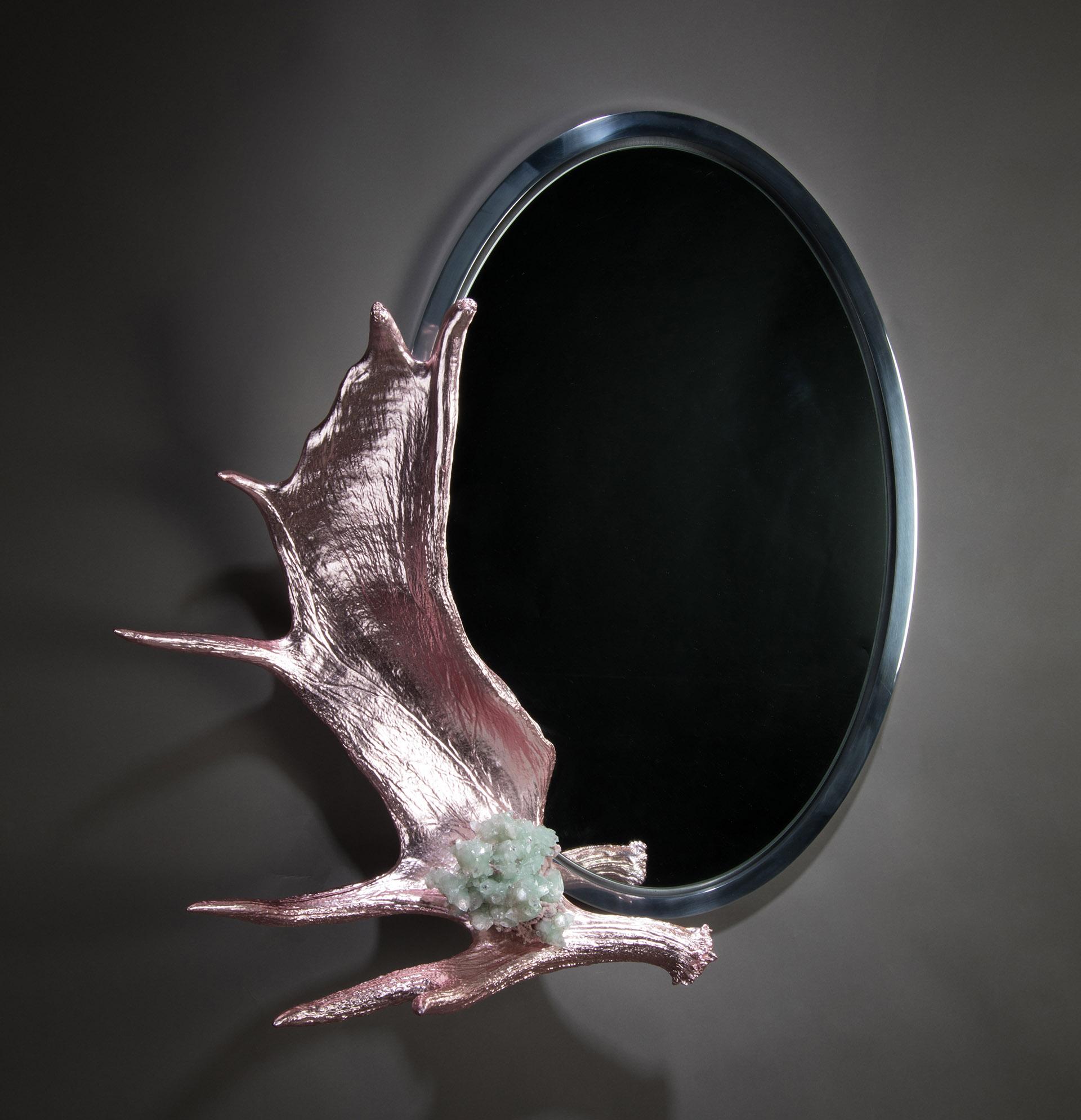 Pink paddle mirror

An apophyllite mineral mounted onto a gilded Alaskan Moose Paddle, the whole mounted to an oval mirror with a polished aluminum frame.
