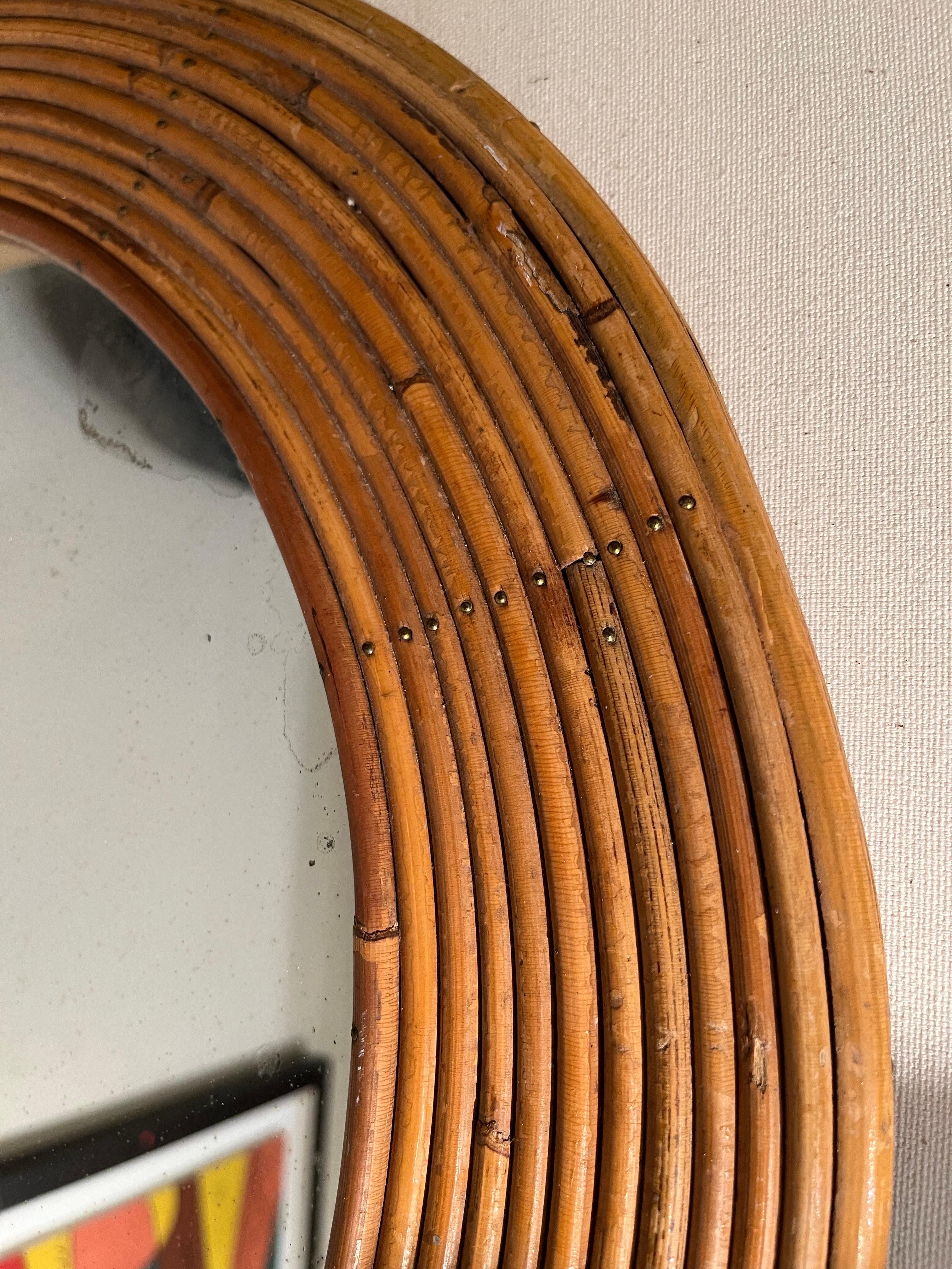 Specchio rotondo in rattan, Italia, anni '60 circa.
La parte in vetro dello specchio è in condizioni vintage, alcune parti presentano segni di scolorimento (vedi foto).
