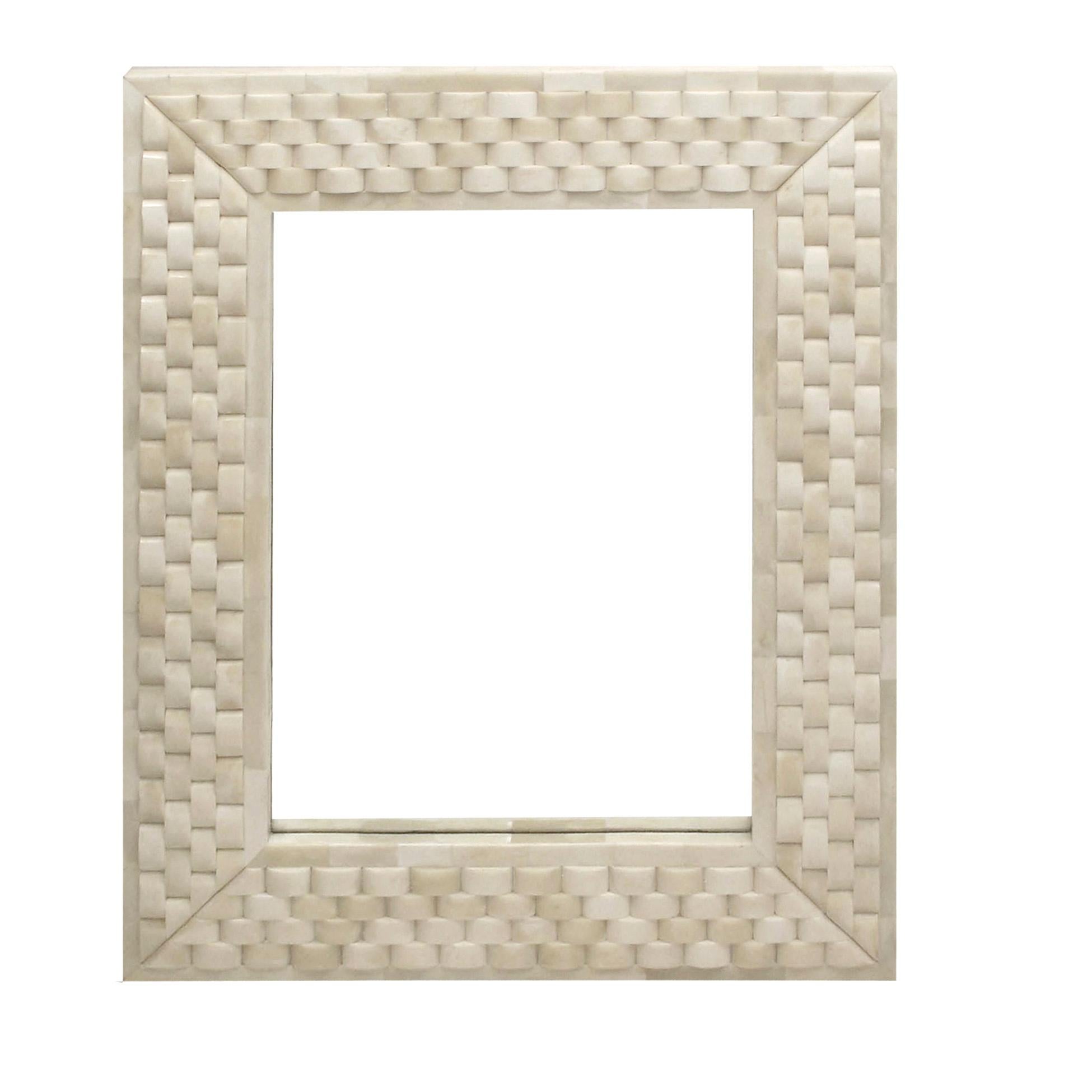 The weave mirror boasts an innovative application of sustainable camel bone. Meticulously carved into a unique concave shape, each chip is hand placed in alternating patterns so that the frame appears to be woven. Comes with a high-shine