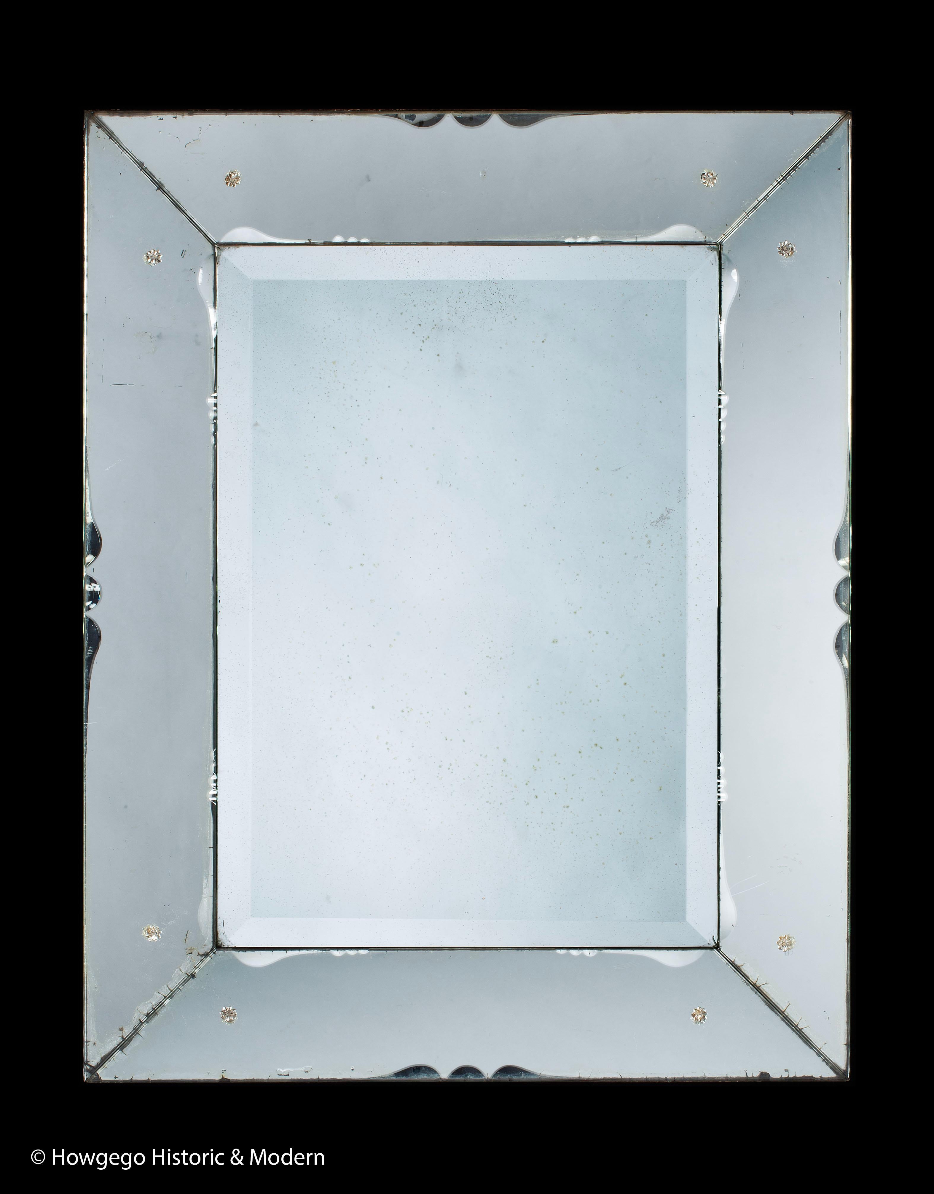 Schöner, großer Art-Déco-Spiegel mit gekantetem Randglas, das einen Rahmen simuliert und mit Jakobsmuscheln in der Mitte der Außenkante jedes Abschnitts des Spiegelrahmens und zwei Wiederholungen an der Innenkante akzentuiert ist. 
Das abgeschrägte