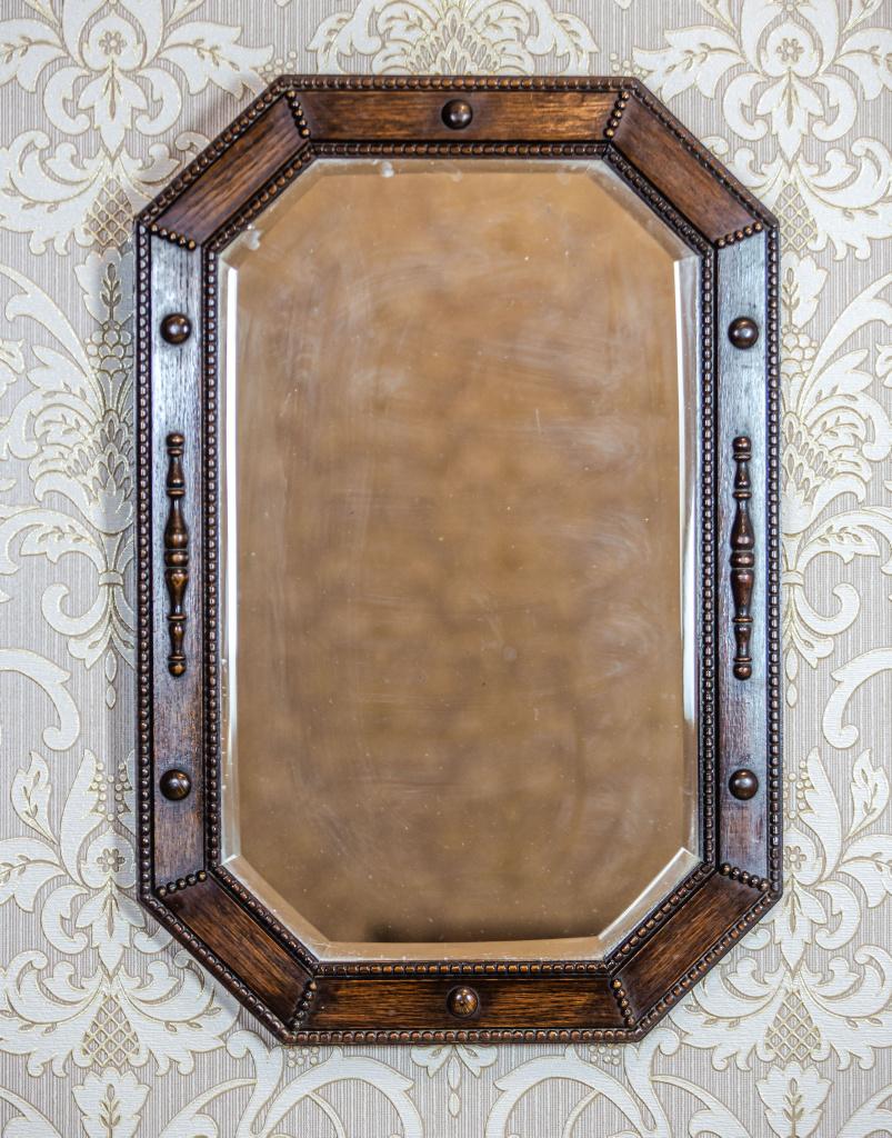We present you a rectangular mirror in an eight-sided oak frame.
The mirror is crystal and chamfered.
The frame is of a simple form, with astragal on the outer and inner edges, and modest appliqués in the form of knobs and semi-plastic, rounded