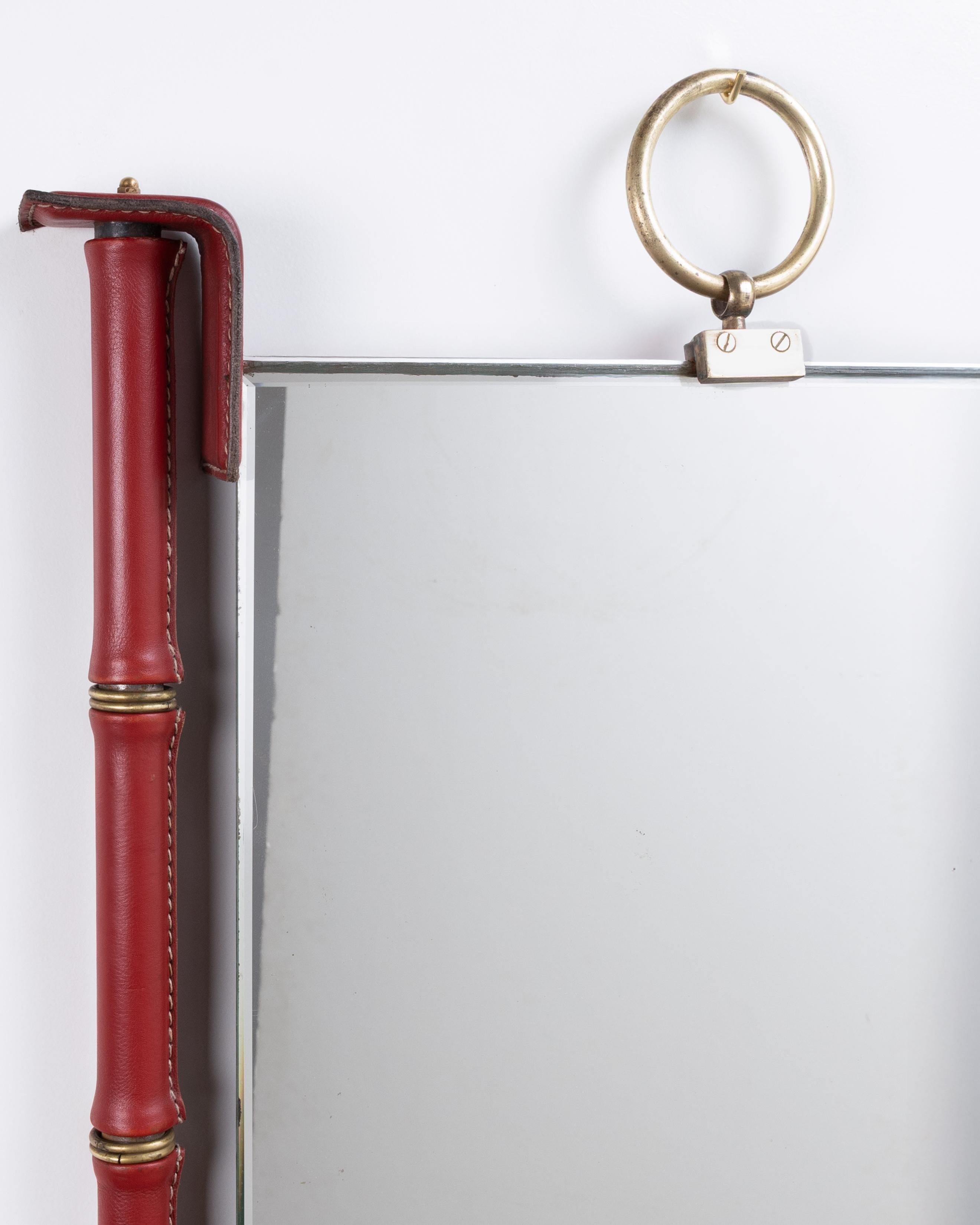 Espejo totalmente revestido de cuero rojo con pespuntes de Jacques Adnet siglo XX en venta