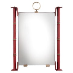 Mirror fully covered in red leather with saddle stitching by Jacques Adnet