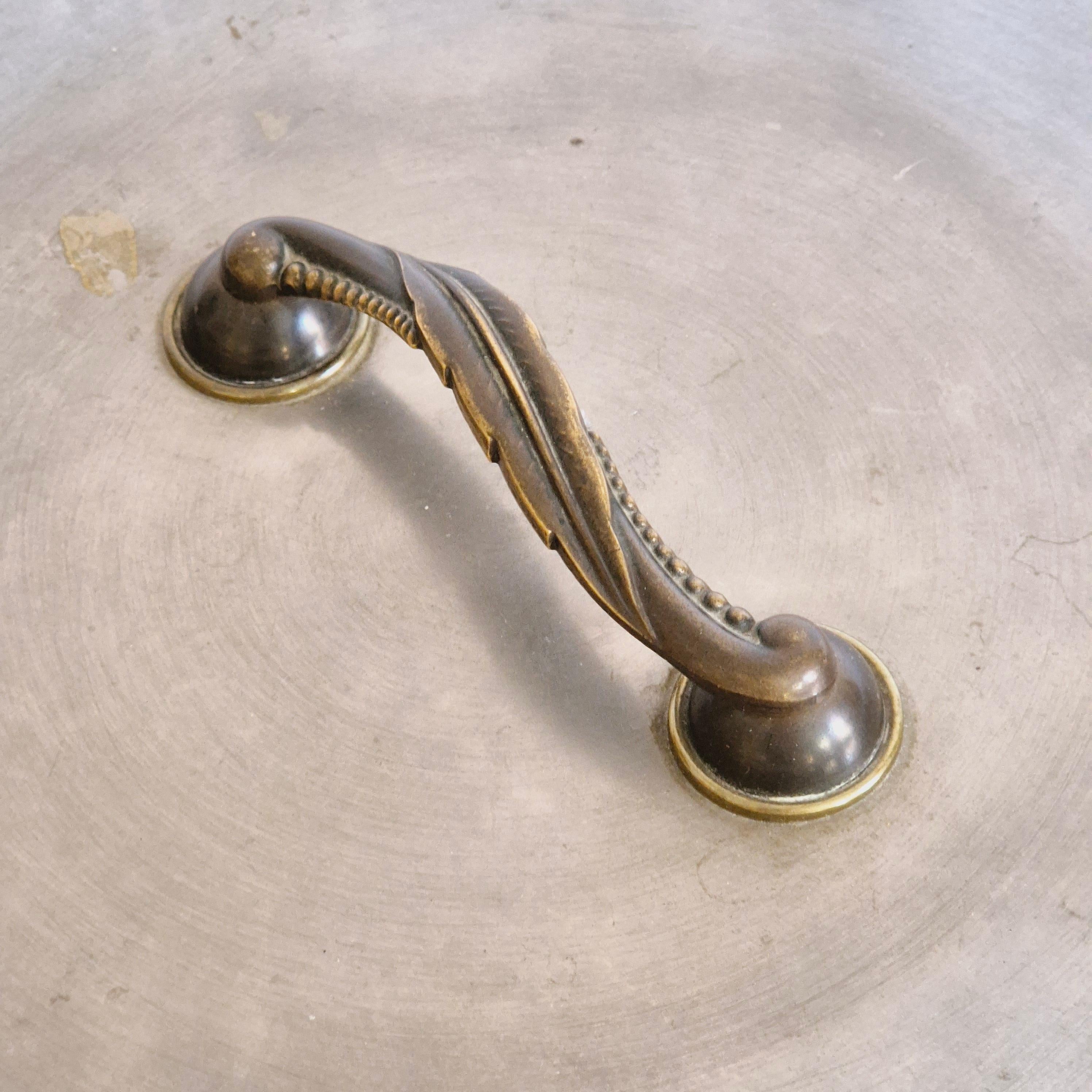 Rare handheld mirror in pewter with handle in bronze and brass, beautiful decor of a leaf. 

Swedish Grace, 1920/30s. In good condition, smaller/normal signs of age and wear. Mirror glass with spots and darkened areas. 