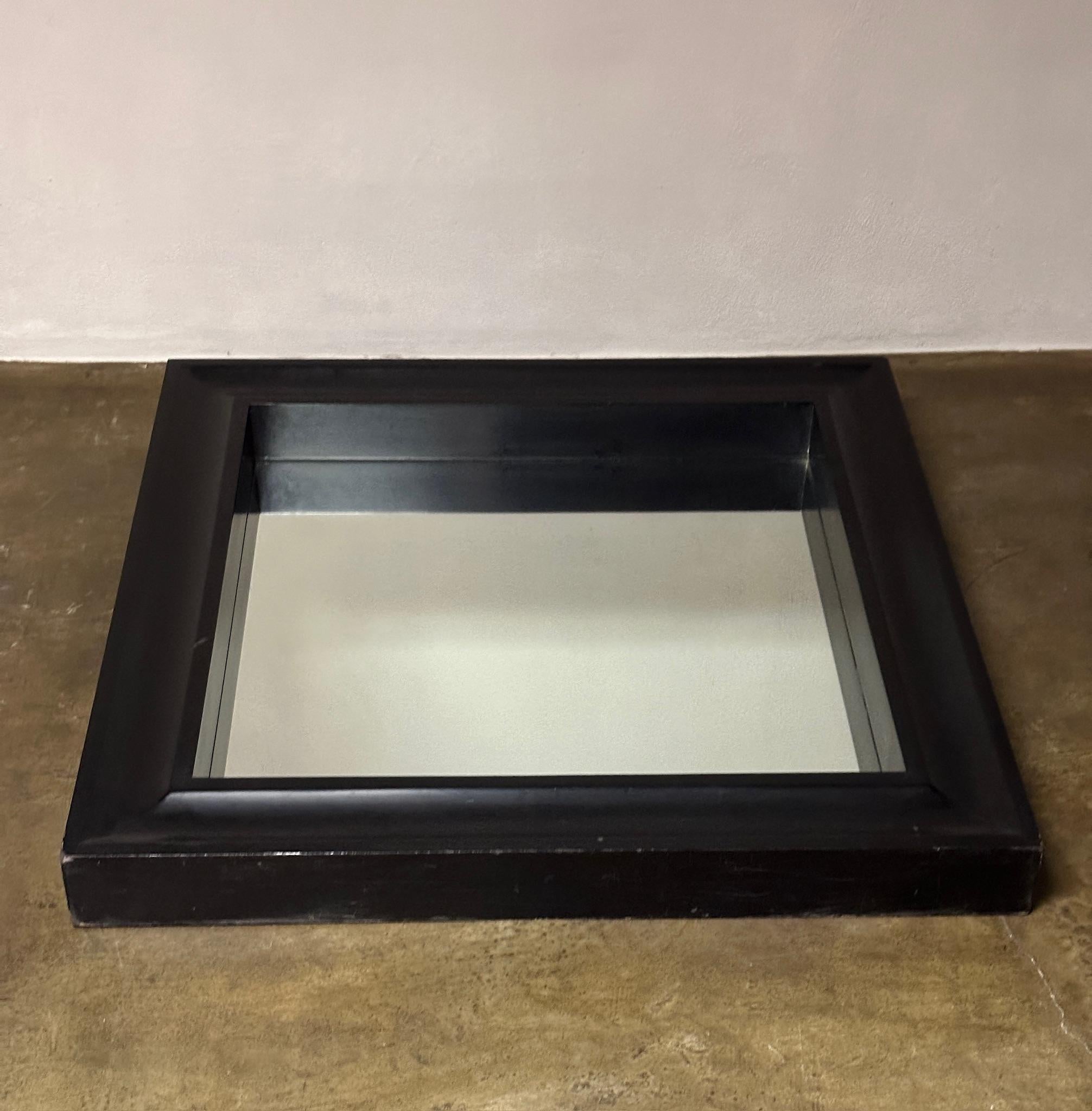 A mid-century mirror with a gutsy square black frame. Perfect for a powder room or small entry space, this timeless piece has an understated, elegant appeal. 

France, circa 1940

Dimensions: 39w x 39H x 4D