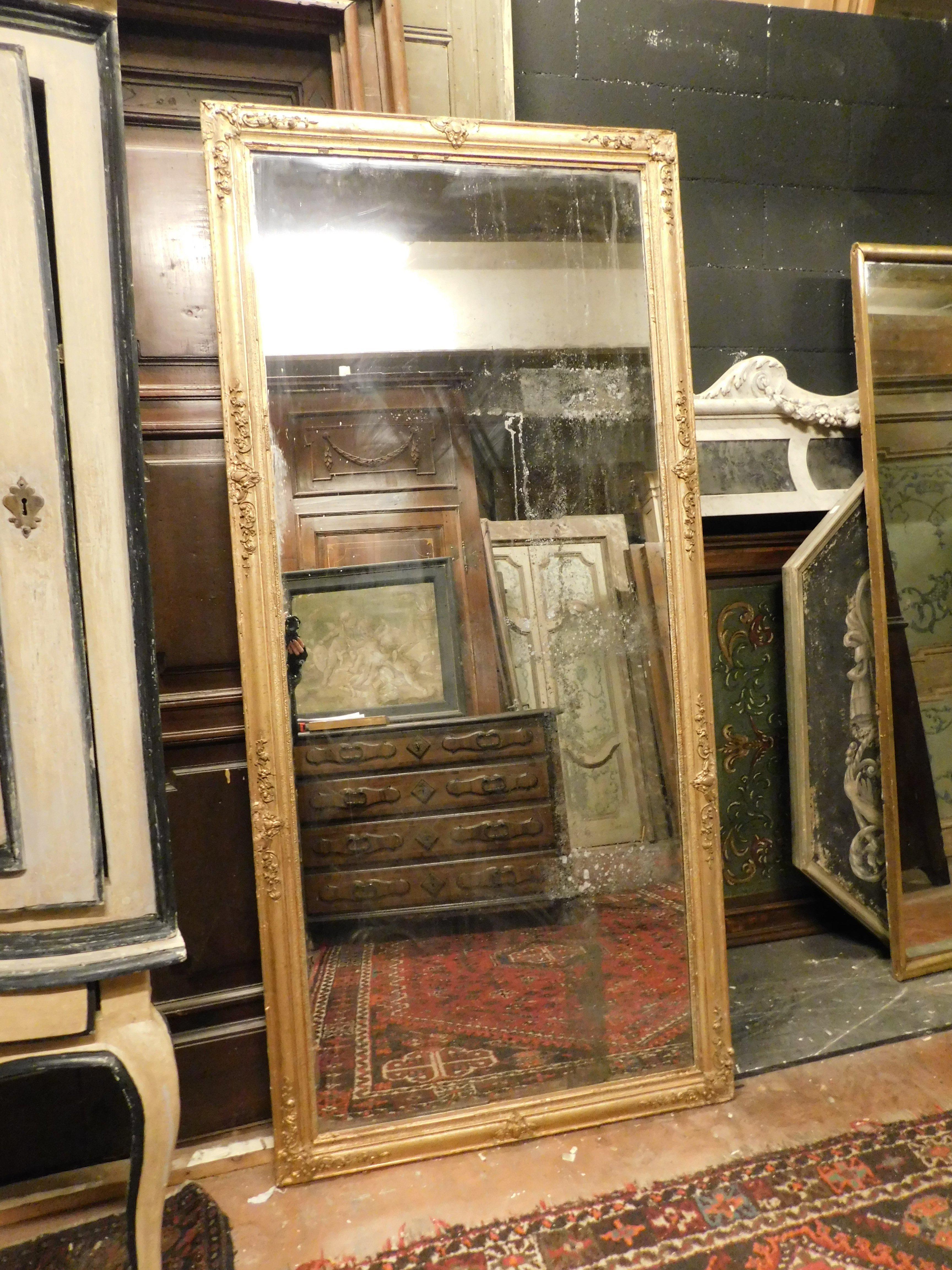 Miroir ancien en bois massif, sculpté et doré à la main, de forme rectangulaire et donc positionnable aussi bien horizontalement que verticalement, particulièrement adapté pour être au-dessus d'un lavabo dans la salle de bain ou dans une entrée de