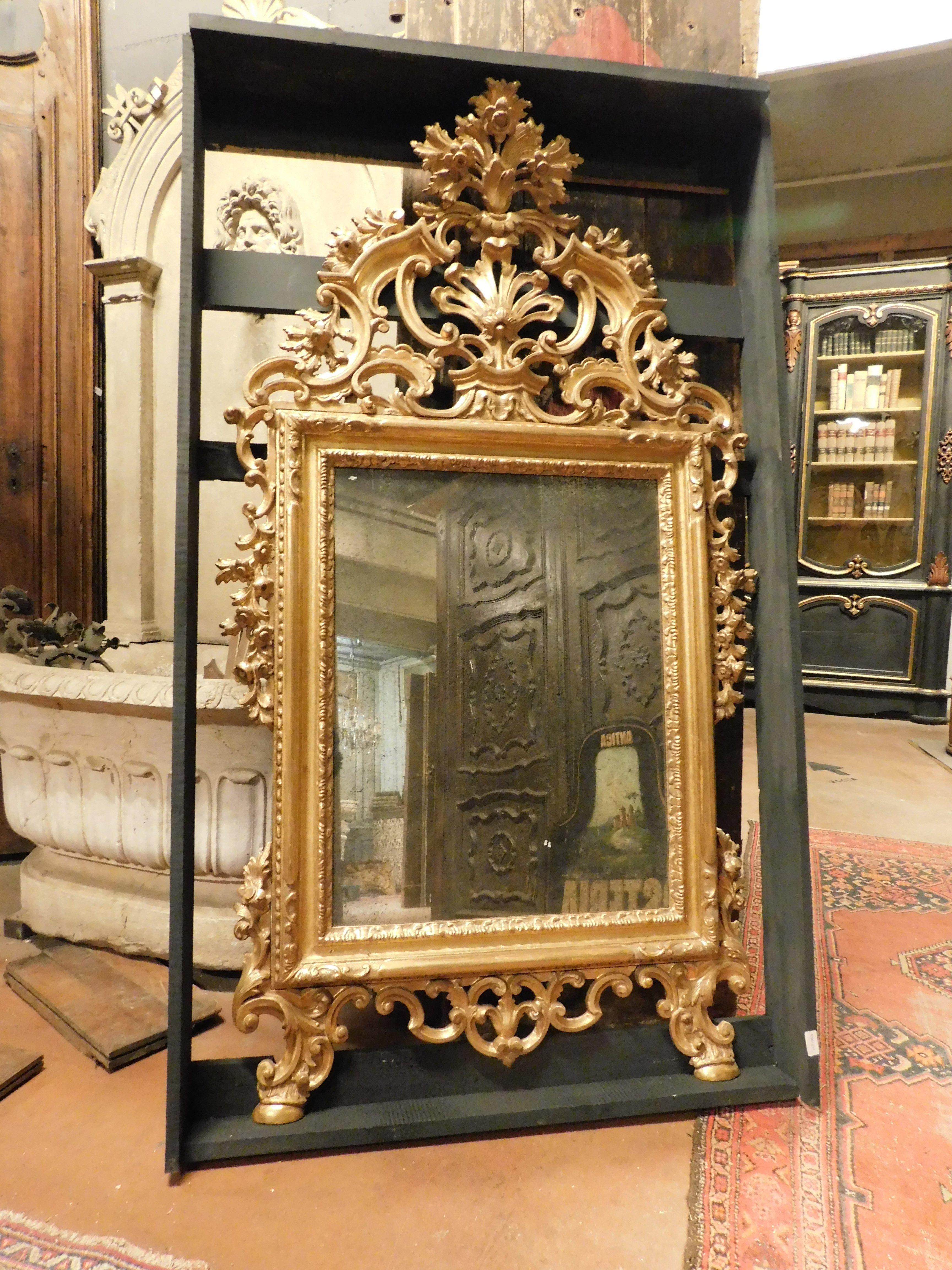 Italian Mirror in gilded wood, richly frieze perforated volutes, floral and leafy, '800 For Sale