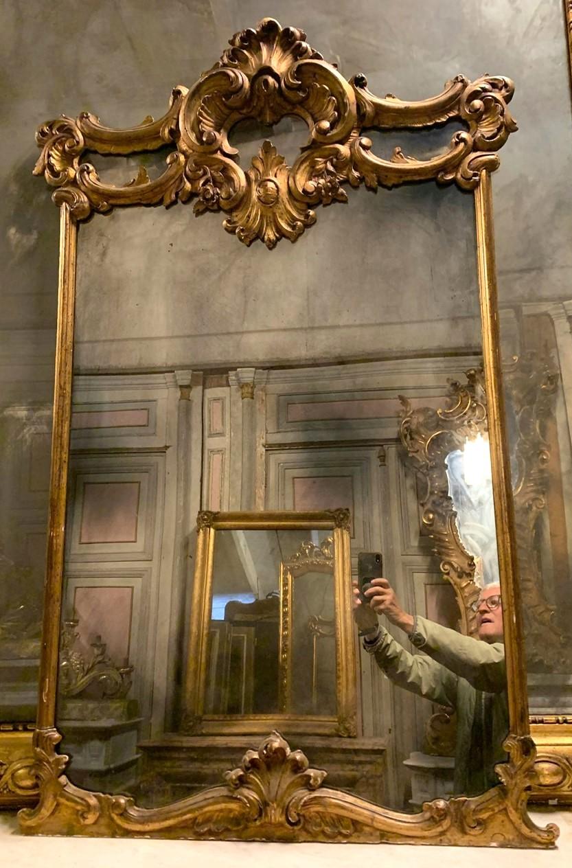 Miroir vintage en bois laqué et doré, surmonté de riches décorations en volutes centrées par des coquillages, de la fin du 19ème siècle, dimensions maximales cm l 85 x H 138.
