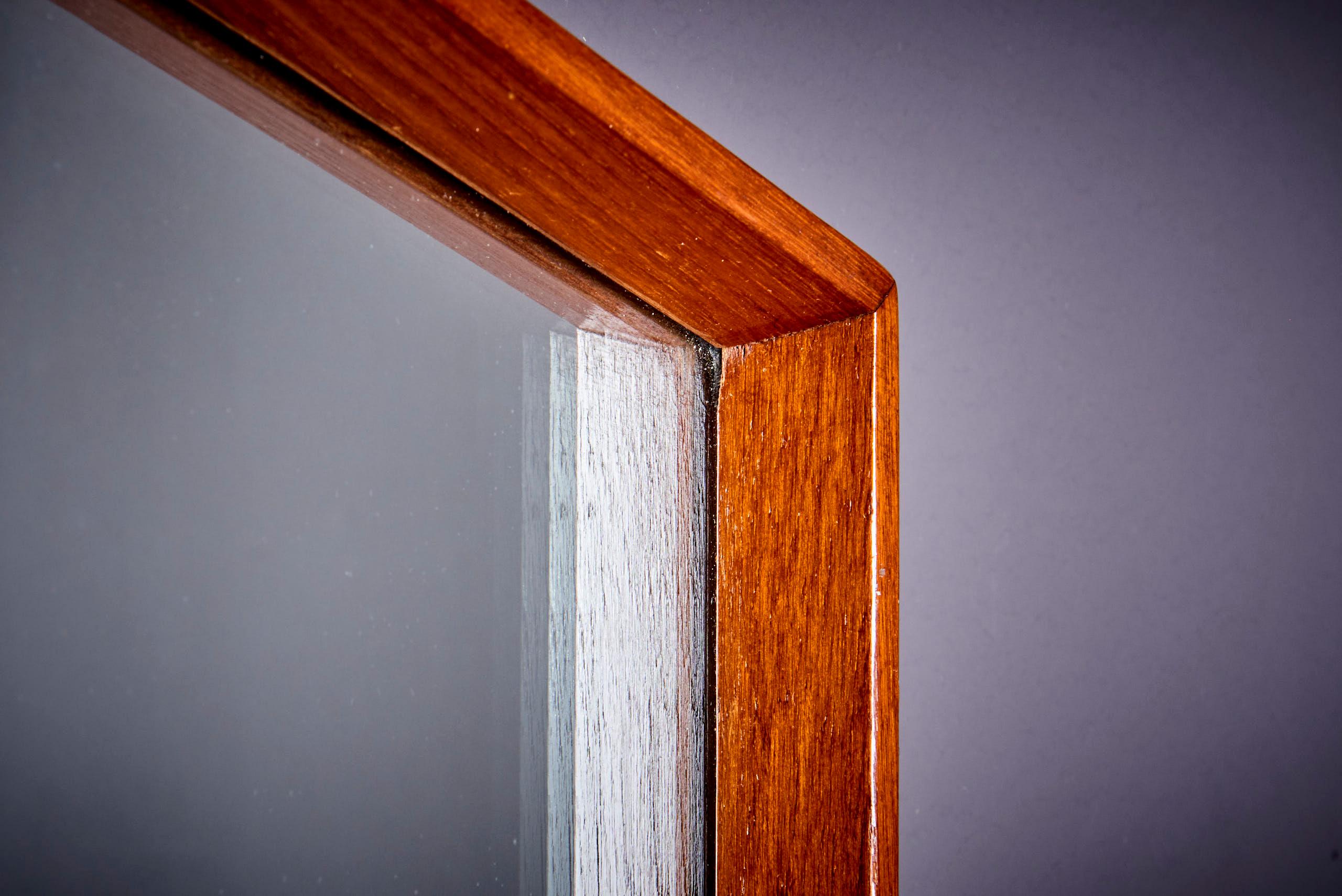 Teak mirror, designed in the style of the renowned Gio Ponti. This piece encapsulates the elegance and simplicity of mid-century modern design. This mirror features a geometric frame made from teak wood, showcasing clean lines and a warm, natural