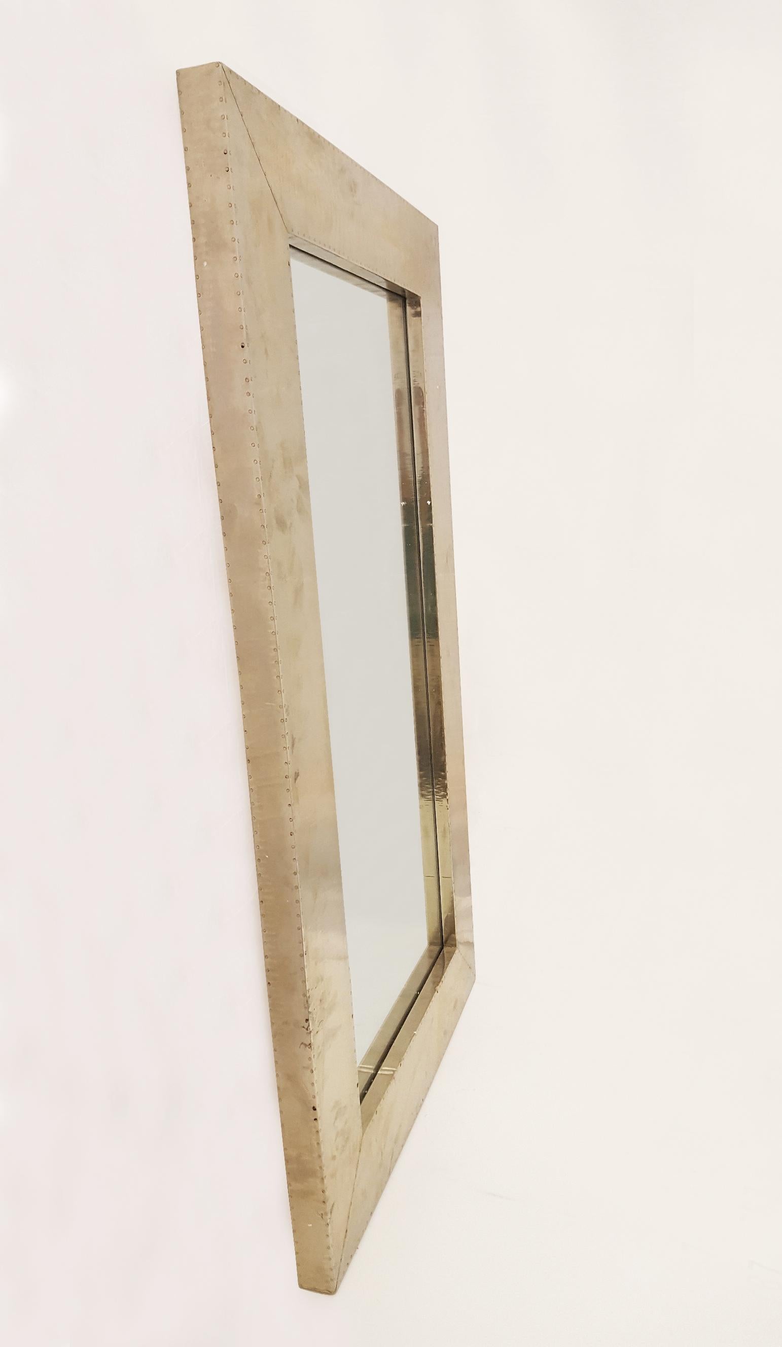 A simple rectangular mirror frame. The metal sheets are attached and covering the entire outside surface of the piece. The available options for metal cladding are brass, white bronze, antiqued bronze, silver and copper. Both silver and copper will