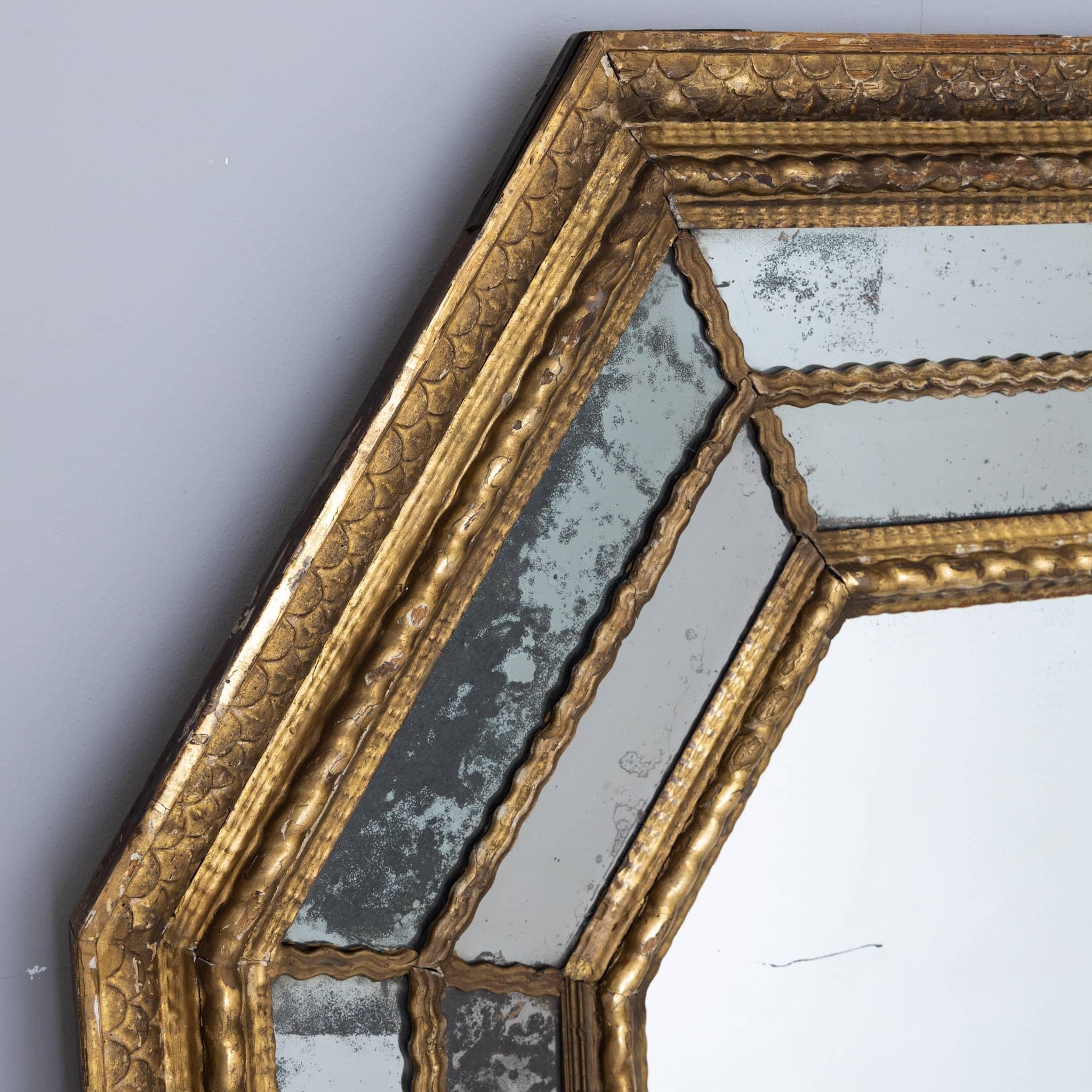 Large wall mirror with gold patinated octagonal wooden frame and old mirror glass blinded in places.