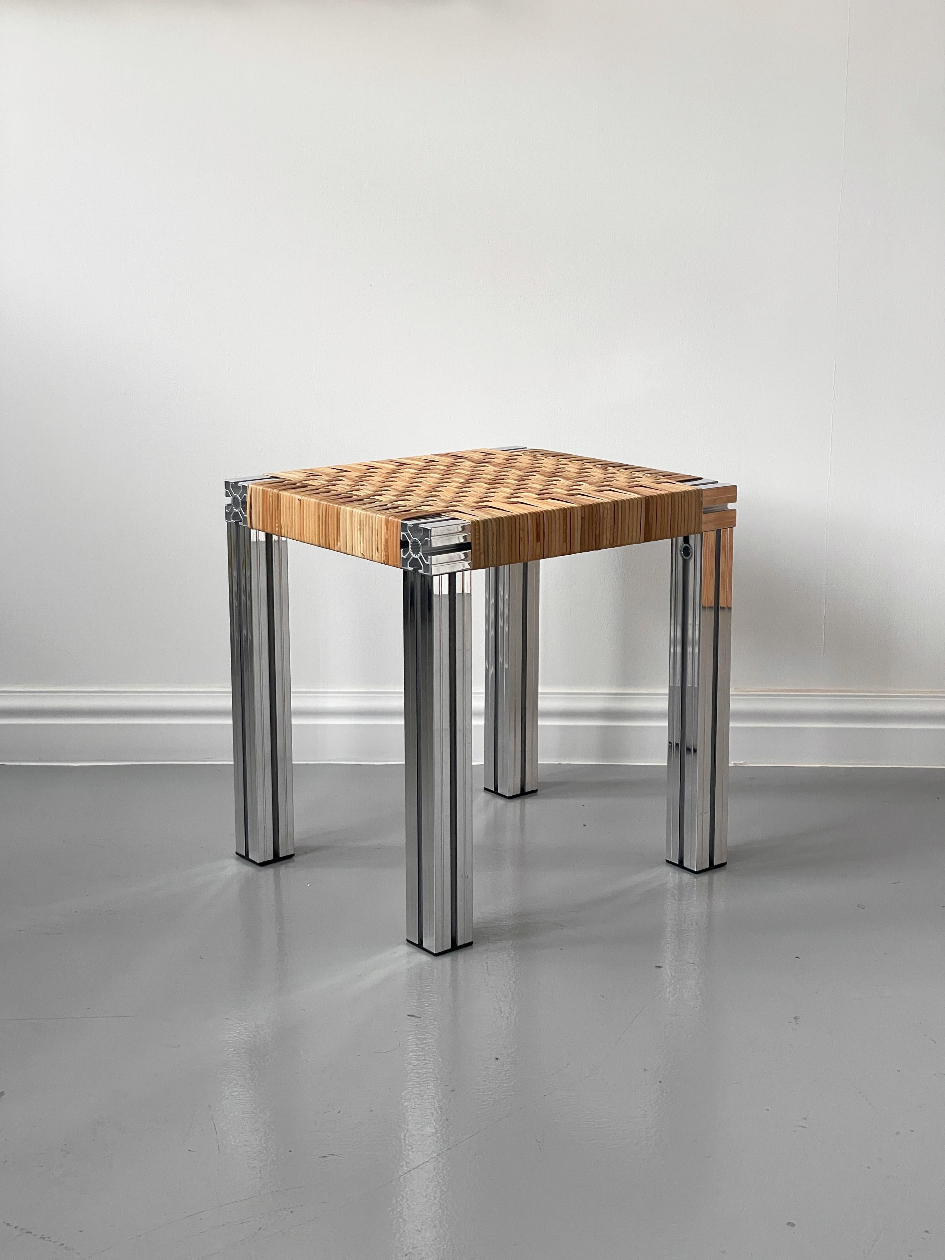 Sgabello realizzato con estrusioni di alluminio lucidato a specchio e seduta in canna intrecciata 380 mm x 430 mm x 450 mm (L x L x H).

Realizzato originariamente per la Hepworth Gallery di Wakefield e ispirato a Donald Judd e Børge Mogensen,