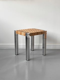 Sgabello in alluminio lucidato a specchio con seduta in canna lappata