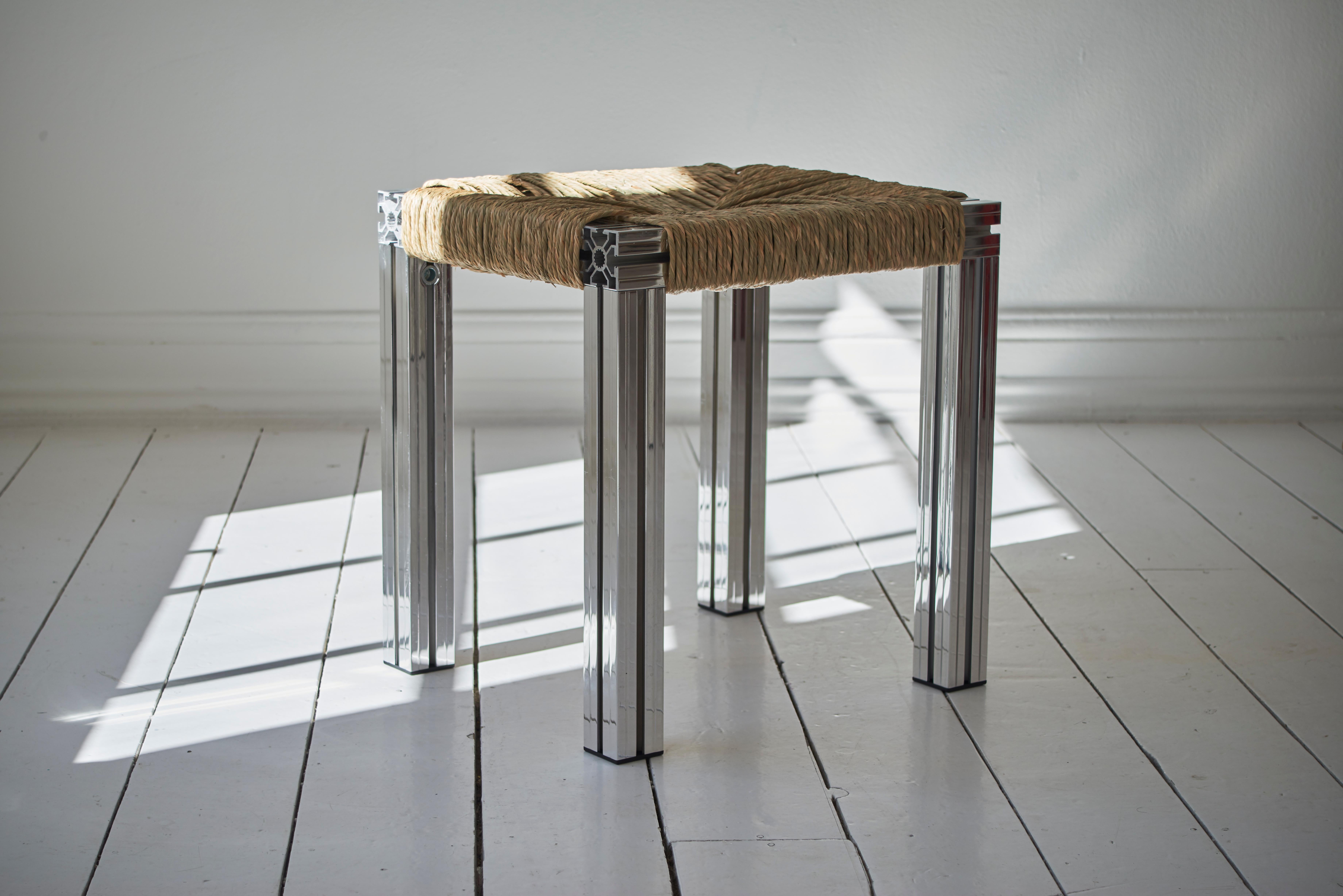 Mirror polished and rush weave wicker stool by Tino Seubert
Dimensions: D 43 x W 38 x H 45 cm.
Materials: Mirror polished aluminum extrusions, rush.

Tino Seubert
When he first made his now signature wicker and aluminium stools and benches in
