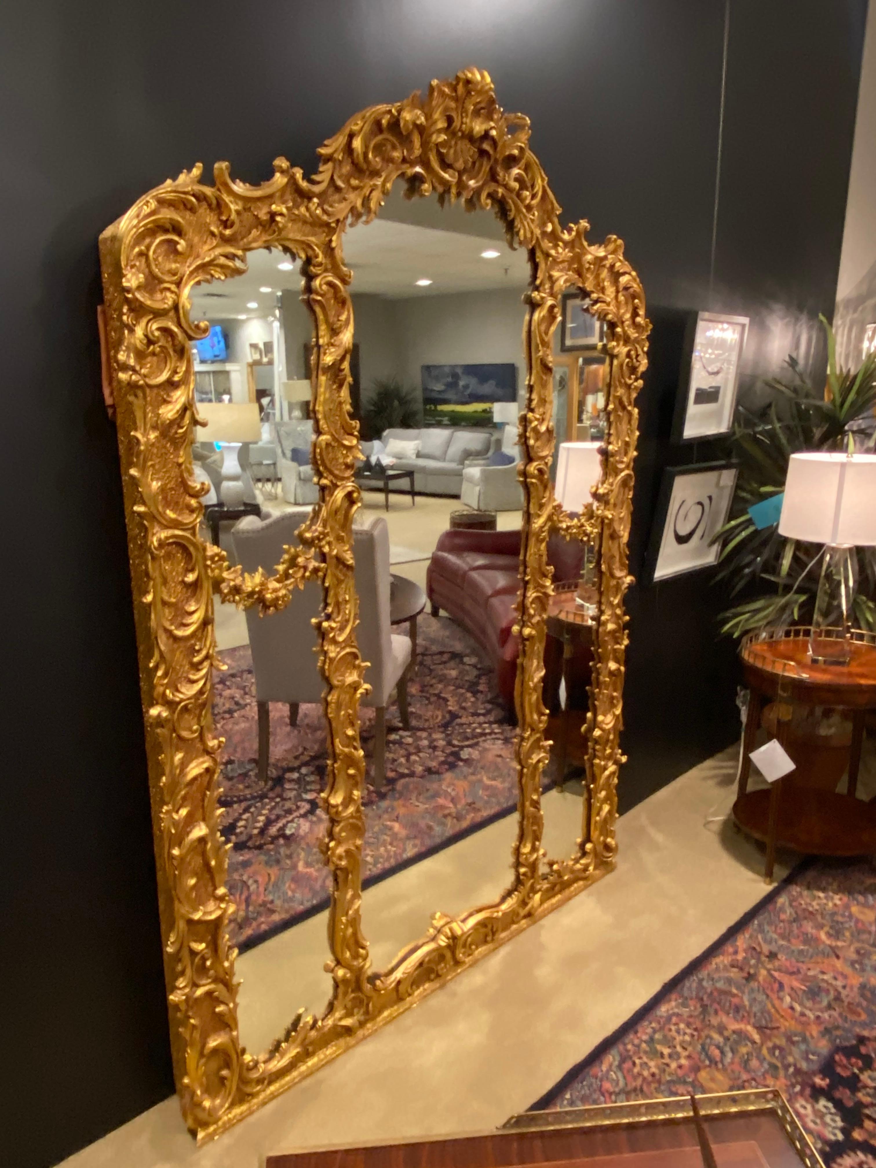 Ein übergroßer Spiegel im Rokoko-Stil mit Blattgold und Gesso-Details wie Blätter und Girlanden. Er hat einen Massivholzrahmen mit einer Rückwand aus Nut- und Federholz. Sie war ursprünglich über einem Kaminsims um die Jahrhundertwende angebracht.