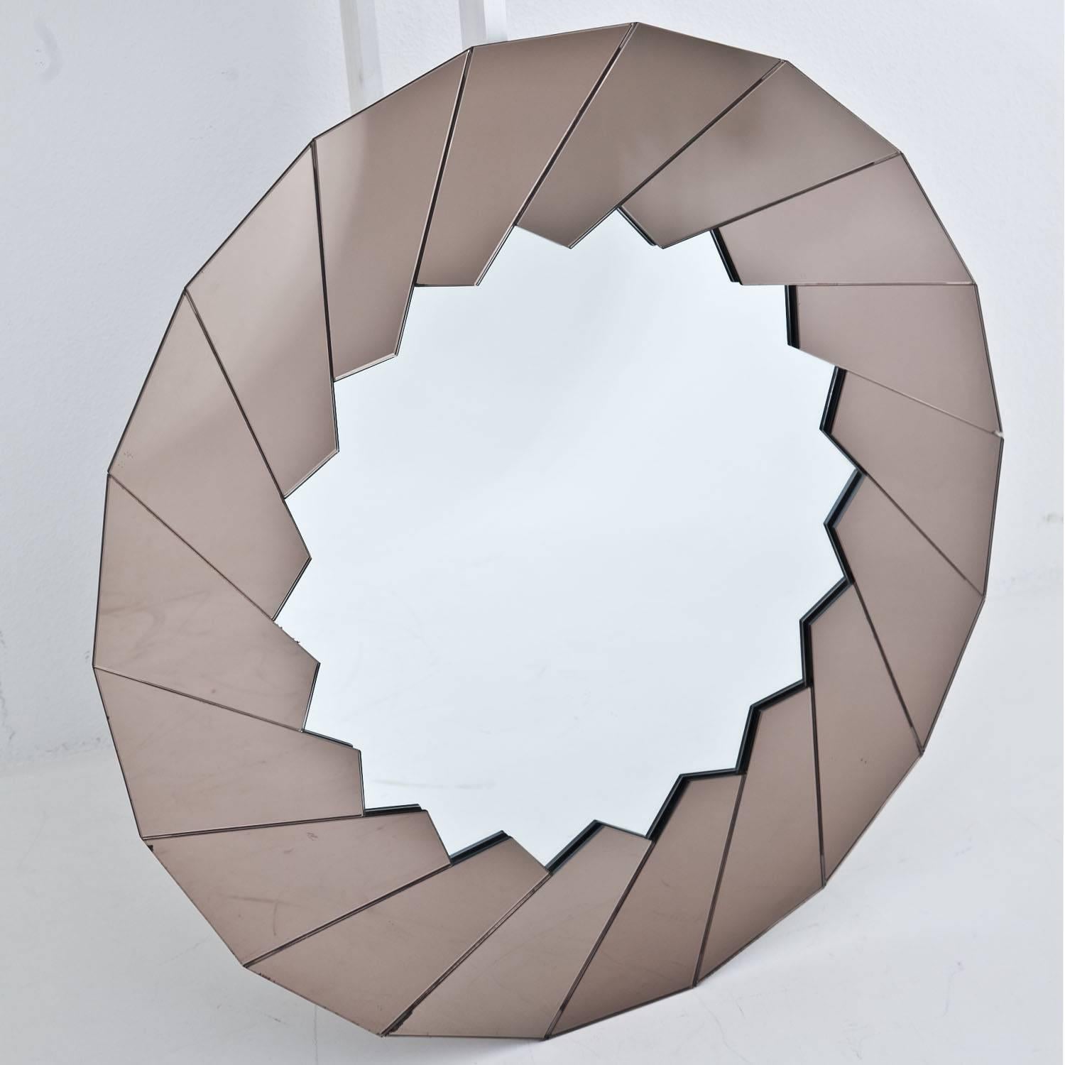 Polygonal wall mirror with a tinted frame and a sun-shaped mirror in the centre. Two smaller chips on the outer edge. Label on the backside.