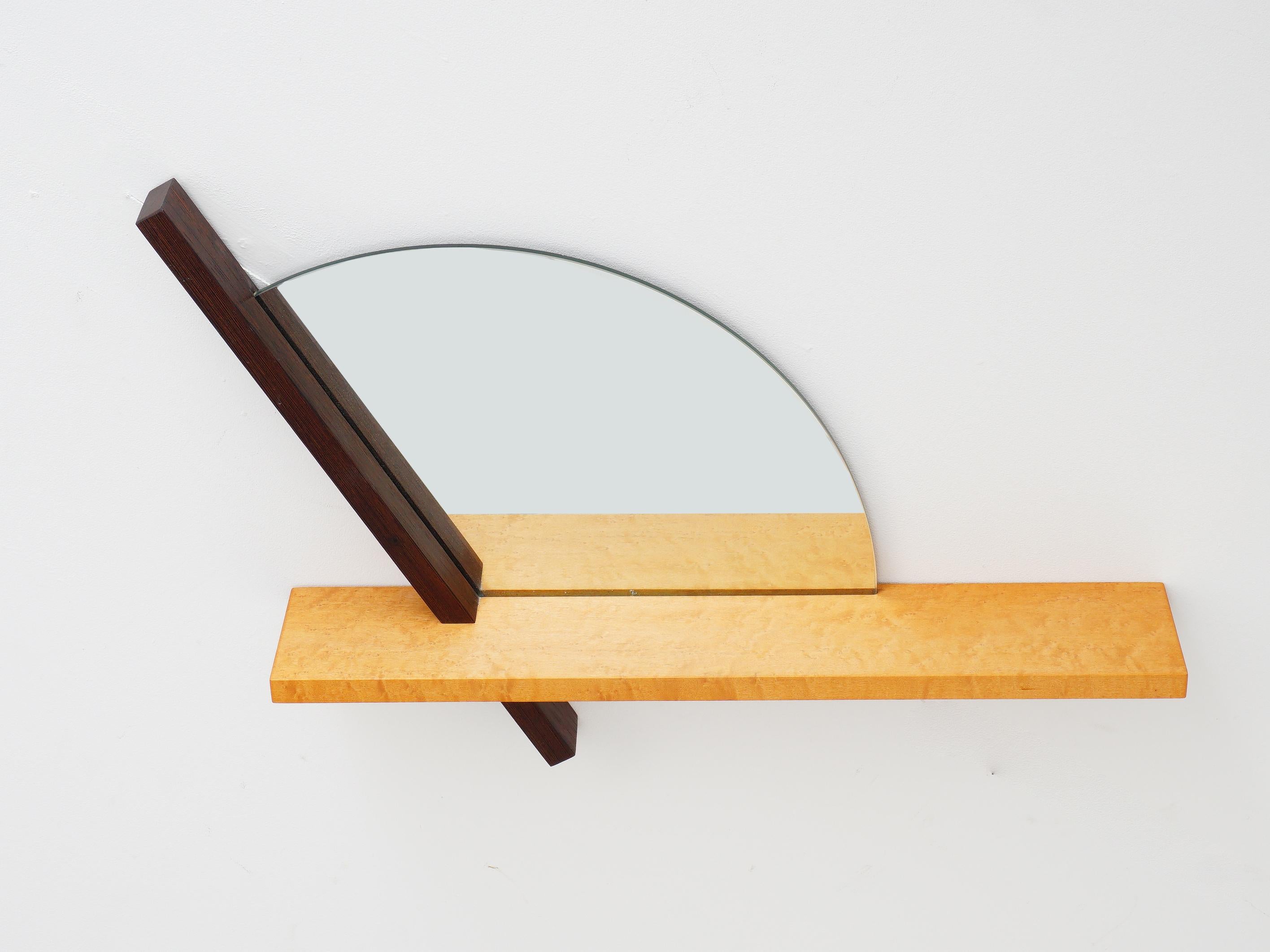 Richard Judd's 1980s mirrored wall shelf is a postmodern masterpiece, seamlessly combining form and function. This dual-purpose gem serves as both a striking wall mirror and a practical shelf, exuding contemporary flair. Its clean lines and mirrored