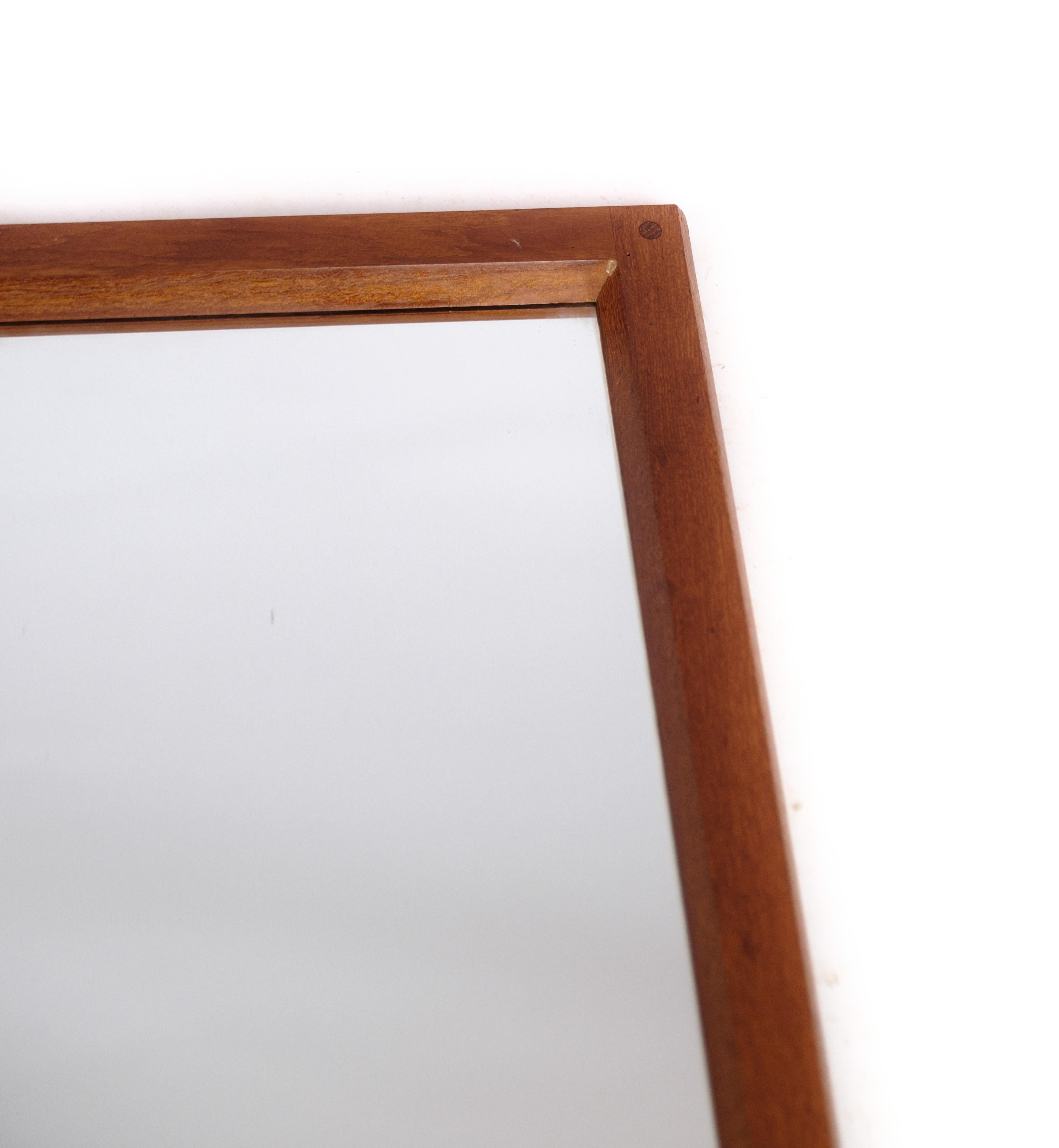 This mirror is a beautiful example of Danish modern design, featuring a frame made of teak wood. The design is attributed to Aksel Kjersgaard, a Danish furniture designer known for his functional and elegant pieces. The mirror dates back to the