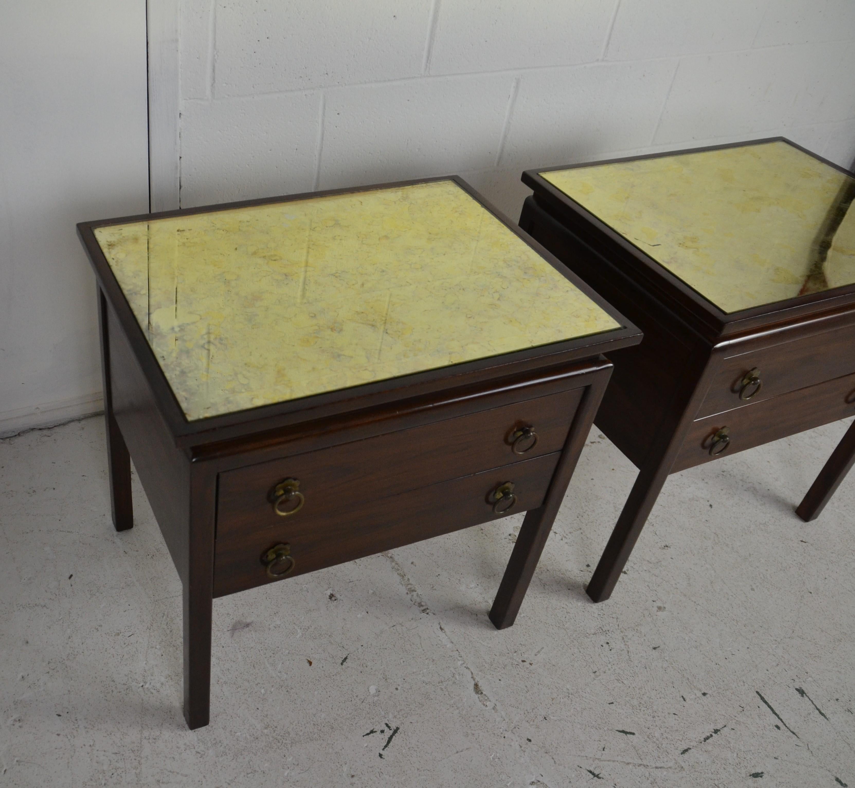 Pair of nightstands with two drawers, inset mirrored top and brass pull.
 