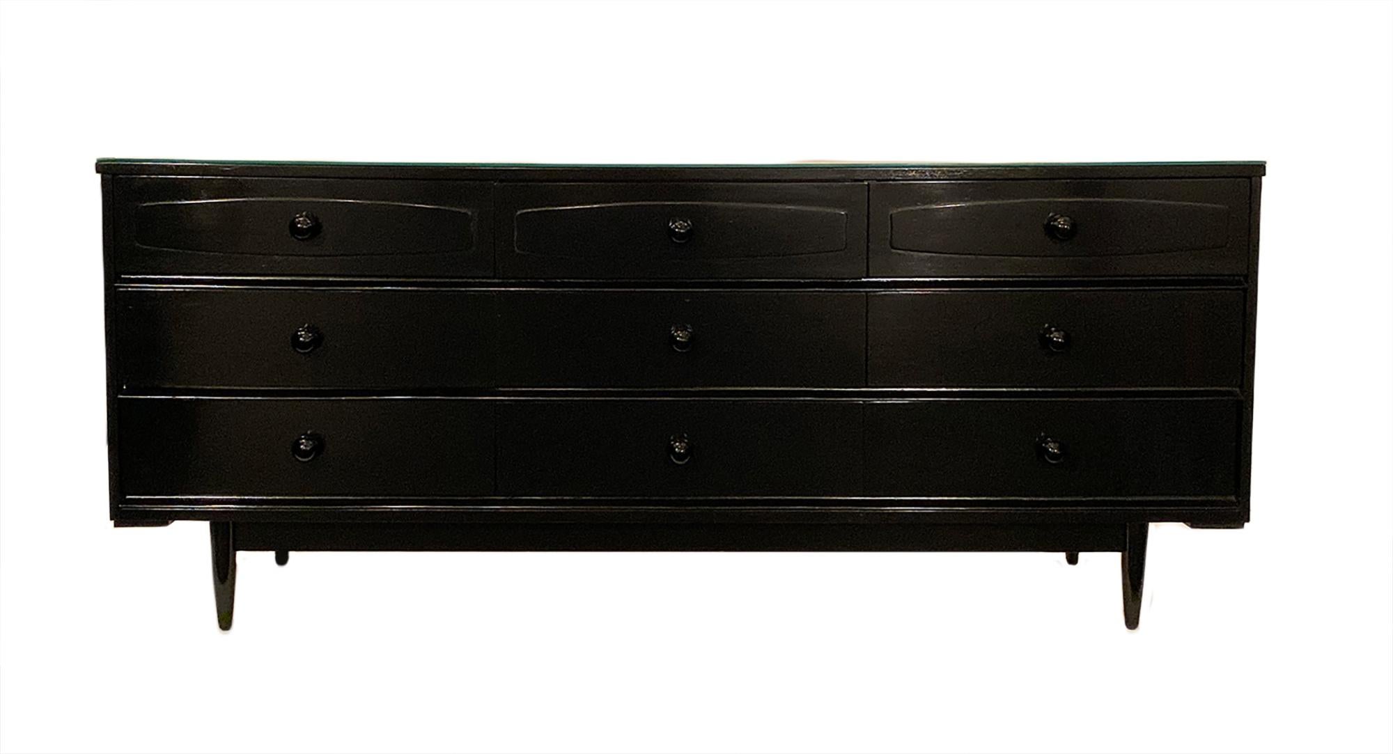 Modernist Danish chest with mirrored top. This piece is made of teak wood with nine dovetailed drawers and black Murano glass knobs. This piece is supported on tapered legs. It has been ebonized and finished with a French polish. A fabulous storage