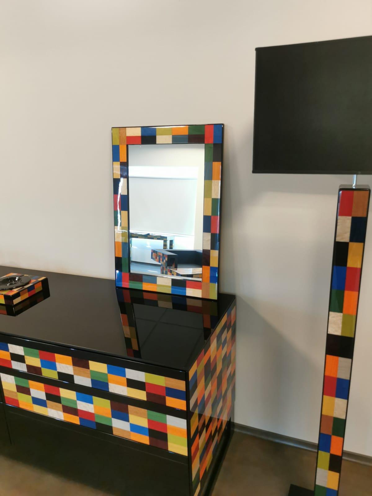 A colorful addition to a modern entryway, hallway, or bedroom or living room, this magnificent wall mirror embodies the perfect harmony between art and design, craftsmanship and aesthetic. Boasting a rectangular silhouette, it is enclosed in a bold