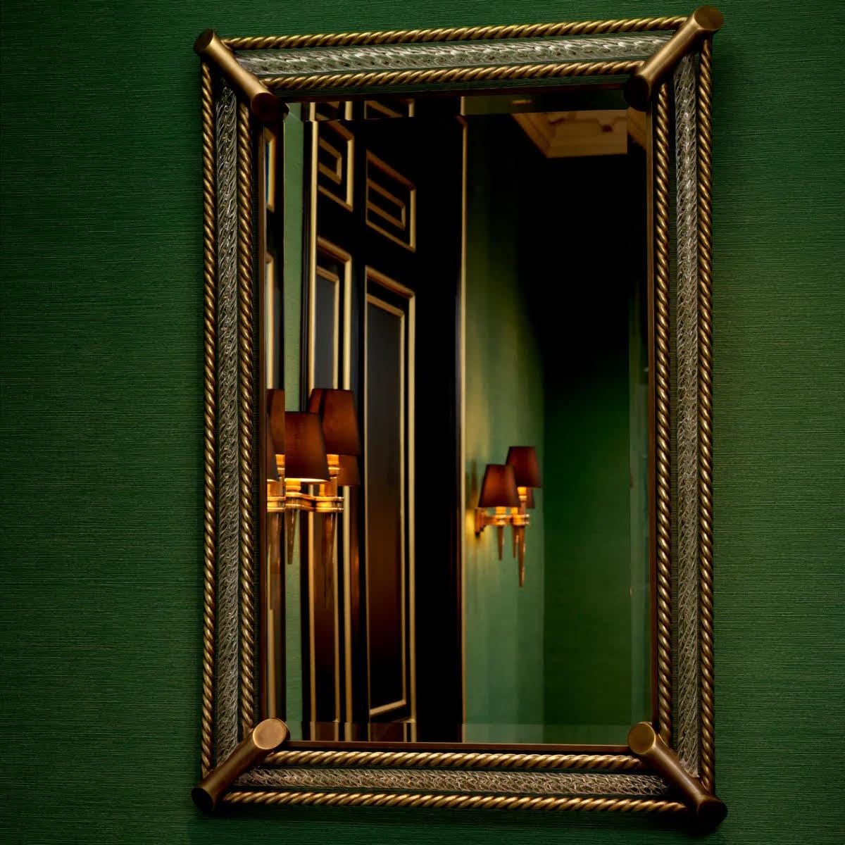 Let the light bounce around, and add style to your lounge, bedroom or hallway with this Mirror.
A frame of brass and hand blown glass around a bevelled mirror makes this mirror stand out in classic and contemporary aesthetics alike.

L. 116  W. 79 