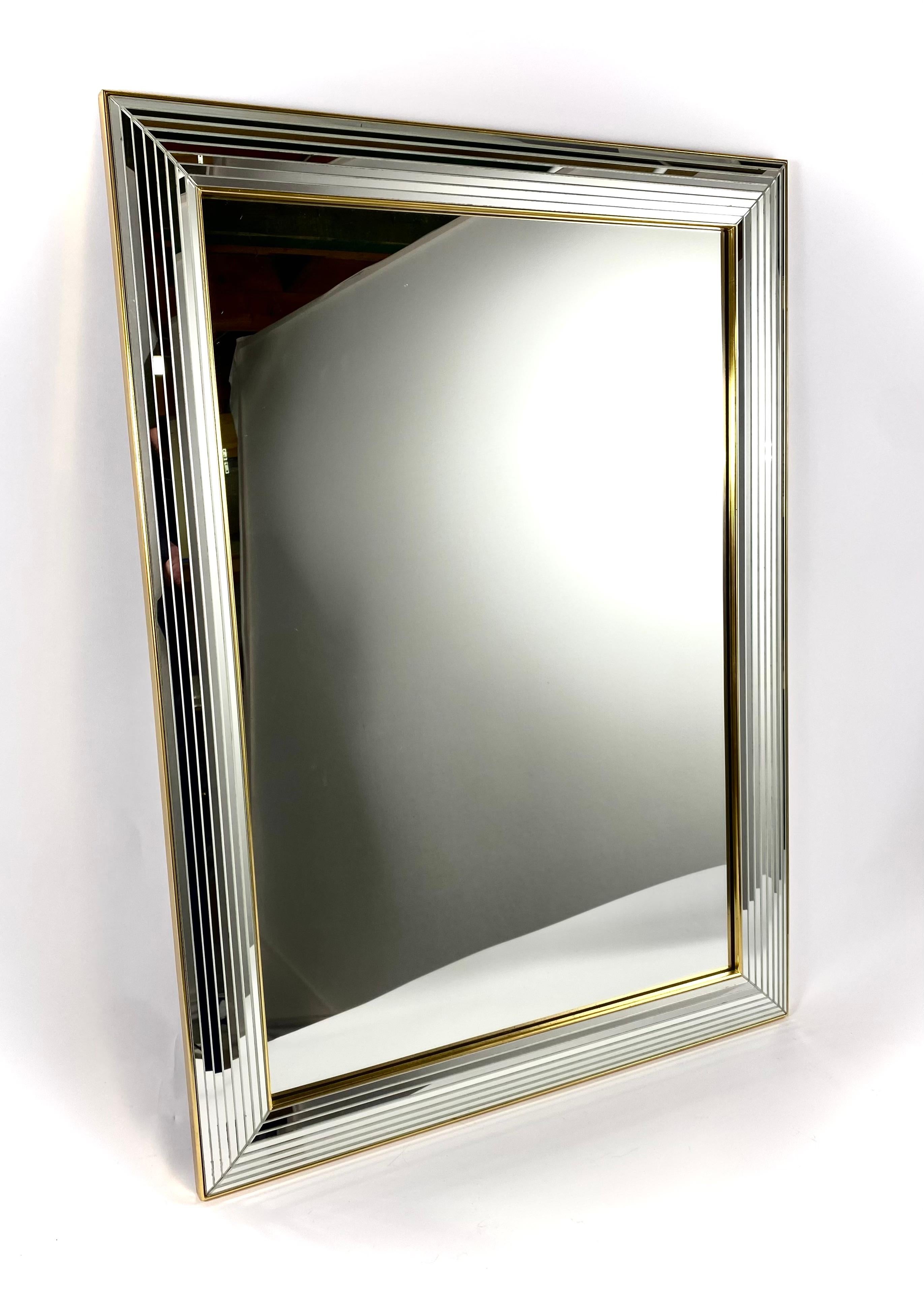 Vintage mirror by the Belgian producer Deknudt from the 1980s in Hollywood Regency style.

Beautiful mirror with a glass frame with a golden strip. The frame is made with small facet cut mirrors in the full width and finished with a brass edge.

The