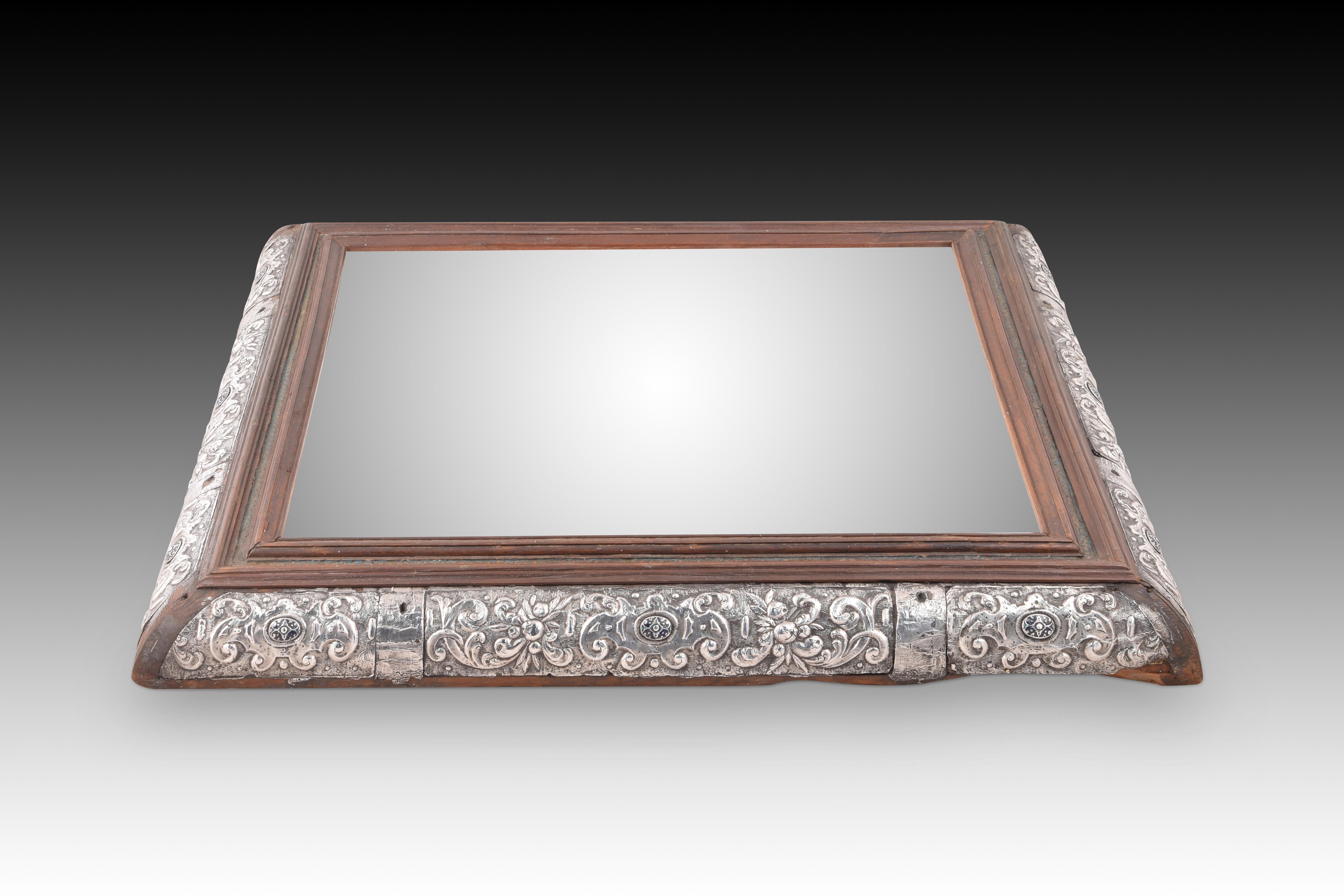 Mirror with cabochon frame. Silver, enamel, wood, stucco, etc. Mexican school, 17th century.
 No contrast marks. It has faults. 
Mirror with a slightly rectangular frame made of wood with polychrome areas and an embossed silver plating on stucco and