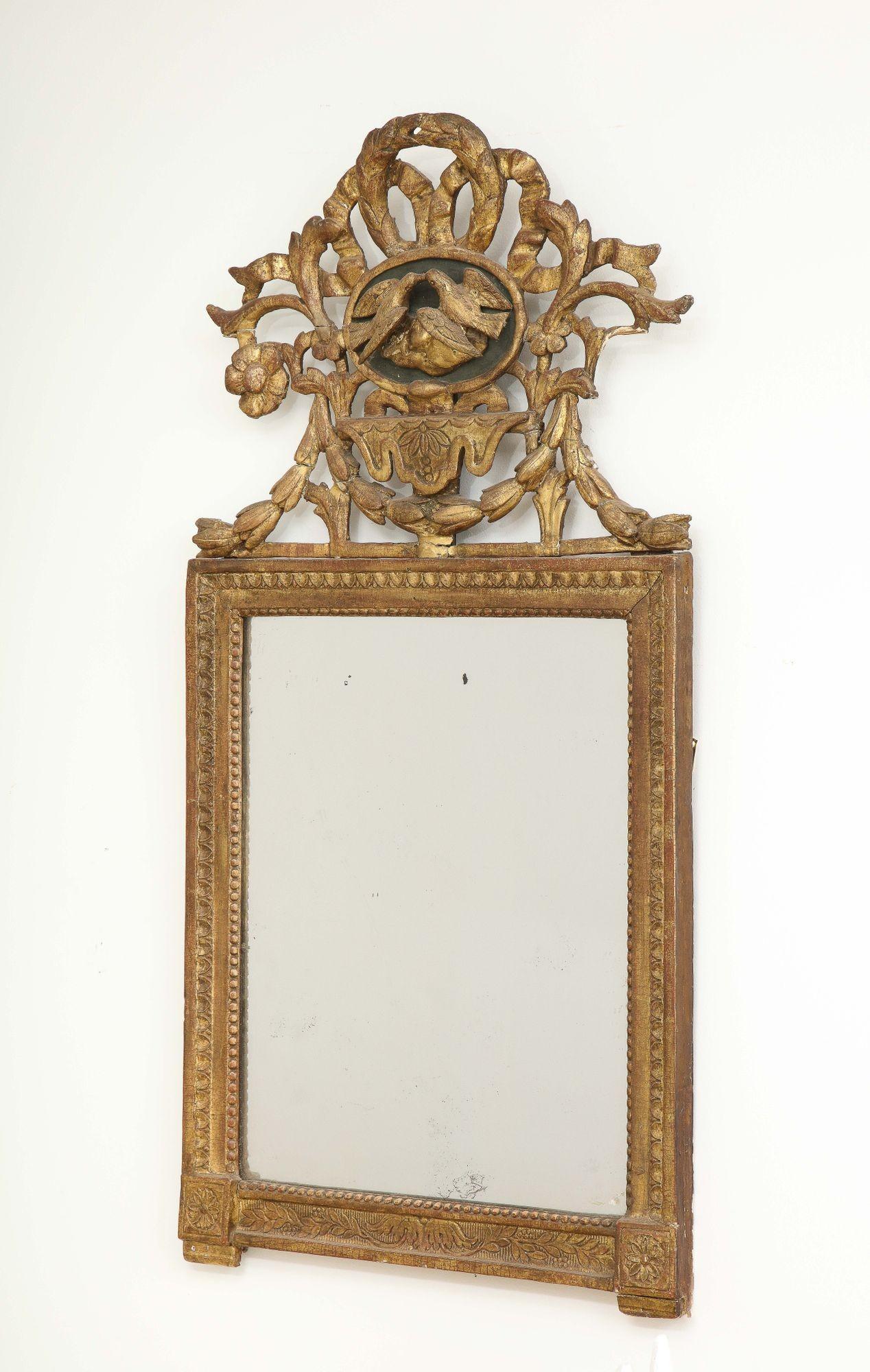 French carved giltwood mirror with ornately carved lovebird crown. Late 19th century. Minor losses and oxidation on the mirror plate.