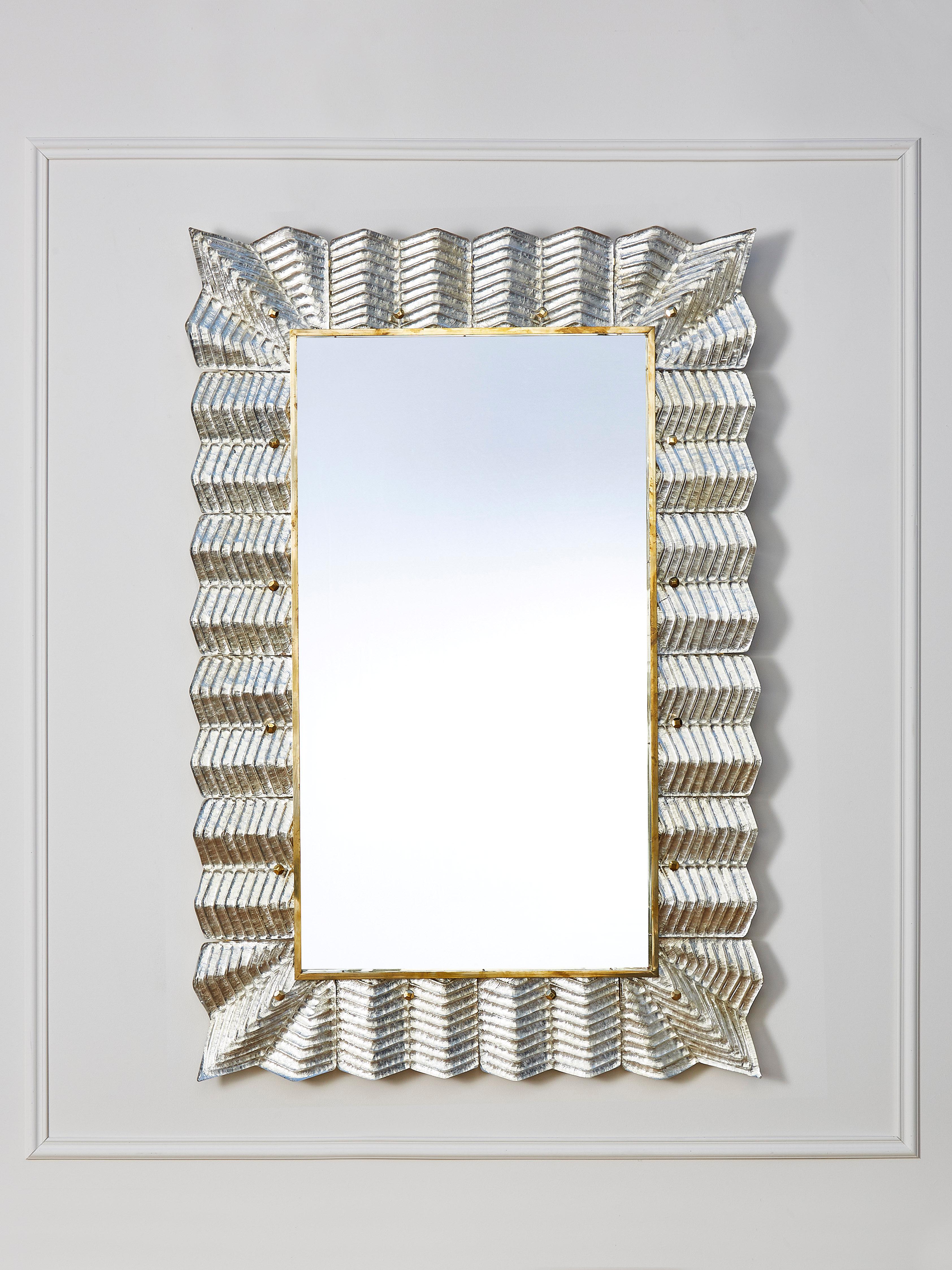 Elegant mirror with a frame made of brass and sculpted Murano glass, gilt with silver leaf.
Creation by Studio Glustin.