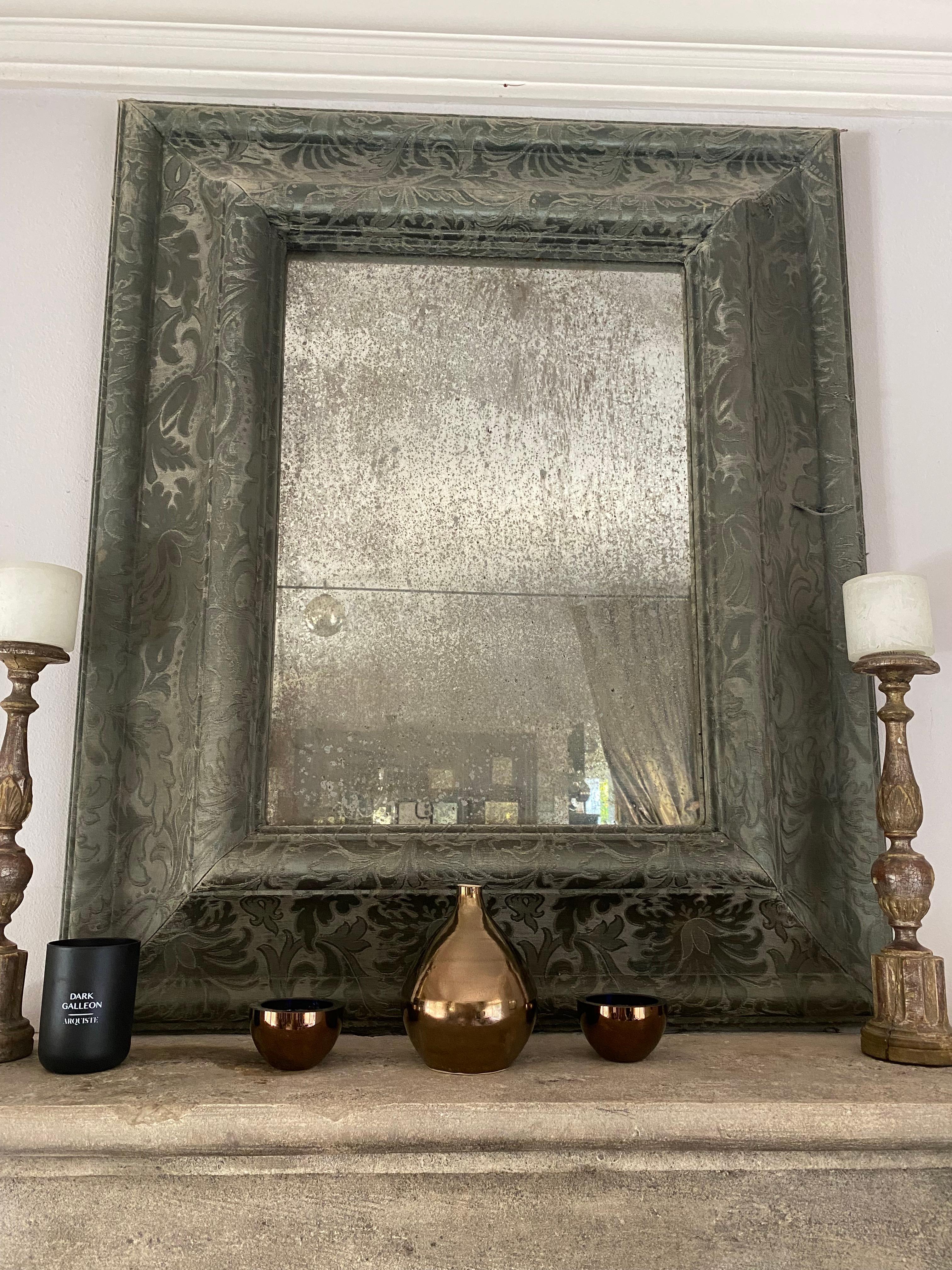 A hand-crafted wood mirror with mitered corners and traditional joinery, completely wrapped in fabric, with antiqued silver-leaf mirror. Custom sizes and finishes available. the first one photographed is upholstered in antique Lyonnaise brocade from