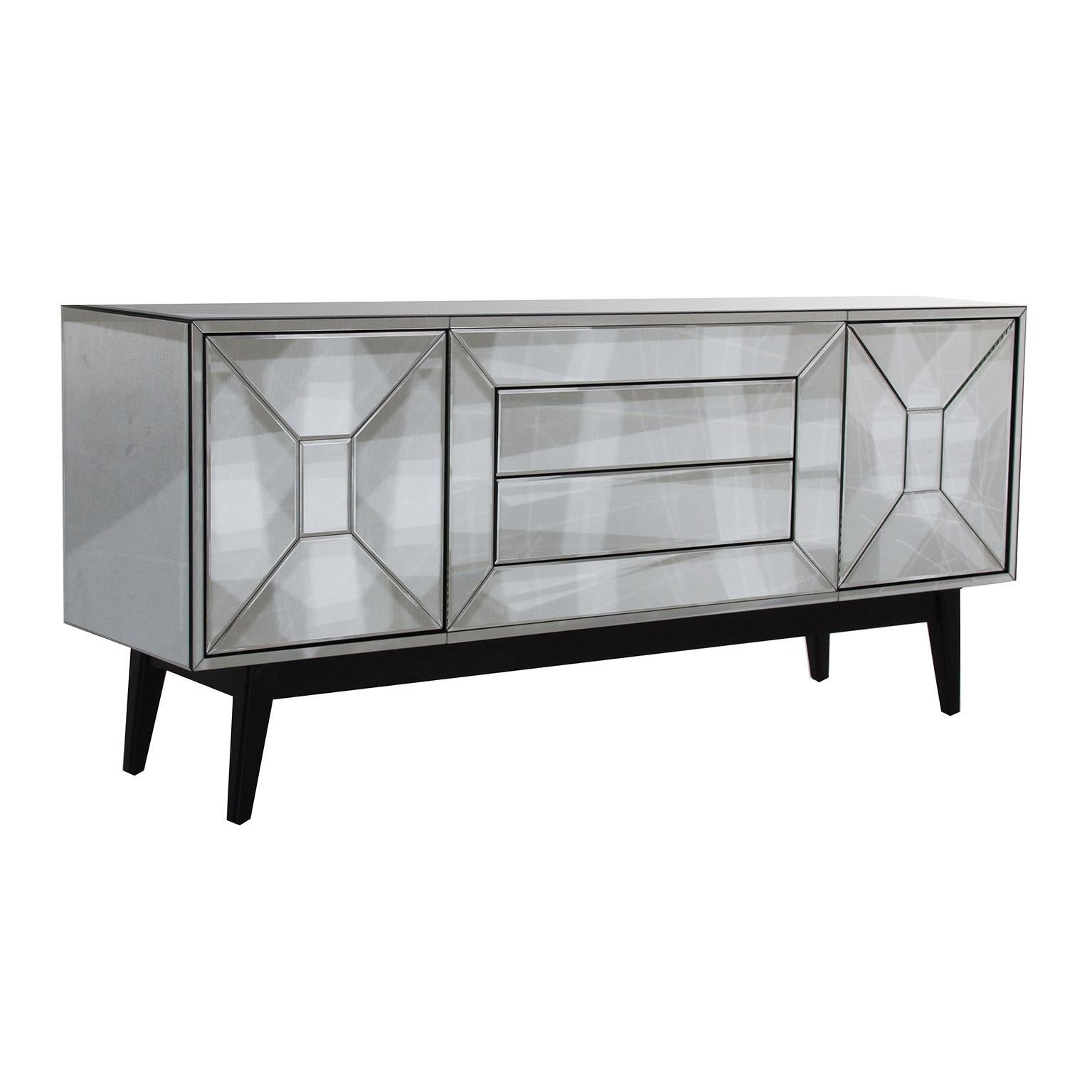 Sparkling and sophisticated all in beveled mirrored sideboard with black wooden and compas feet, two beveled mirrored doors with push-open system and two drawers in the middle. Harmonious lines, graphic and original design.