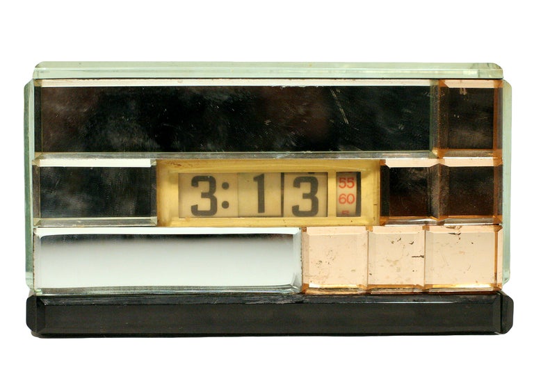 This 1934 Art Deco digital clock by Lawson Clocks Limited of Los Angeles features dual-toned (silver and peach) mirrored glass paneling along the front and sides and a polished aluminum back. It is set off by black glass panels along the bottom.