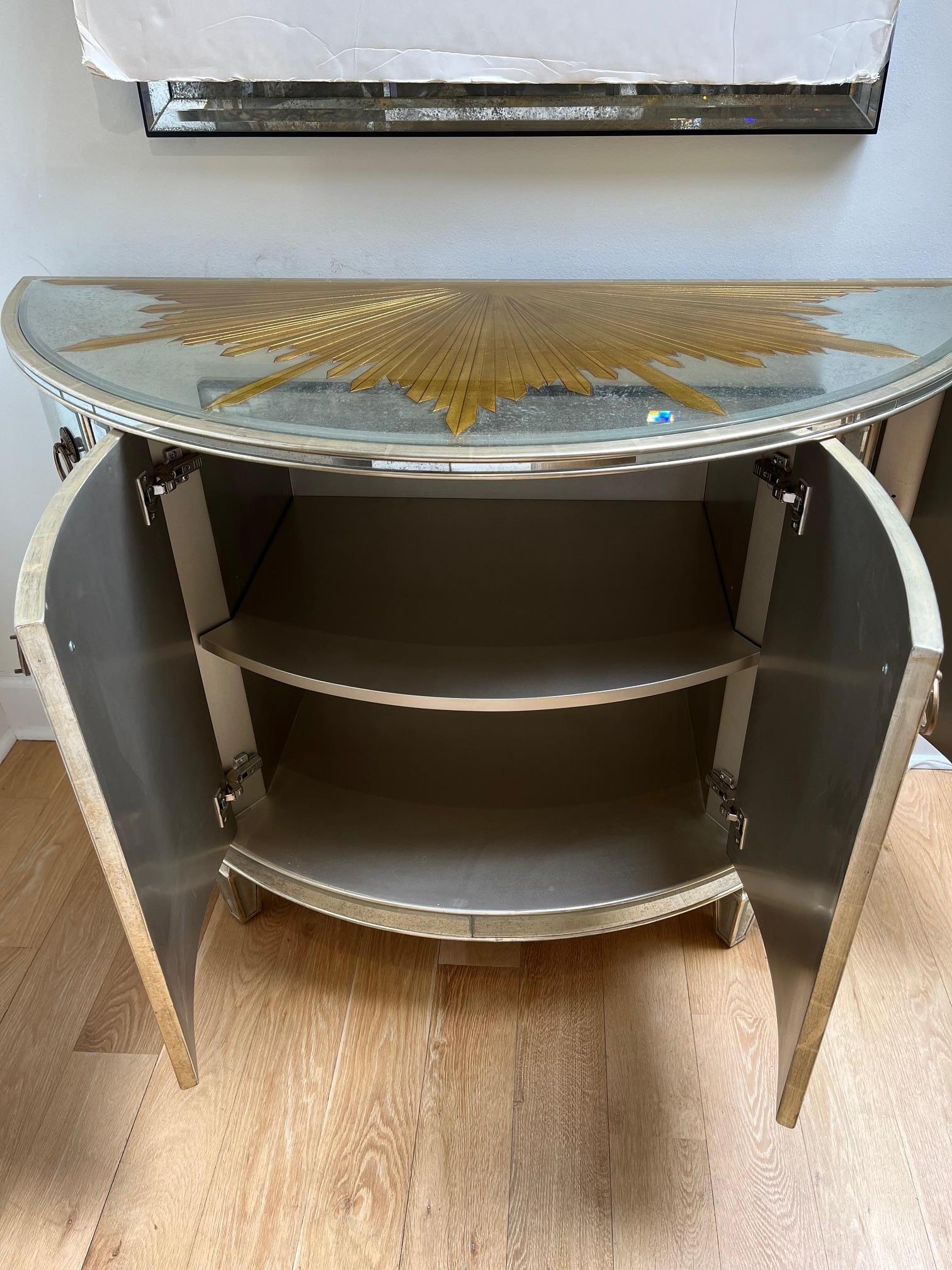 21st Century Pre-owned Picturesque Mirrored Carved Demi-Lune Console with Starburst Gilded Etched Element, Featuring Mirrored front four swing open Doors in 12kt White Gold Finish, a Pair in Stock.