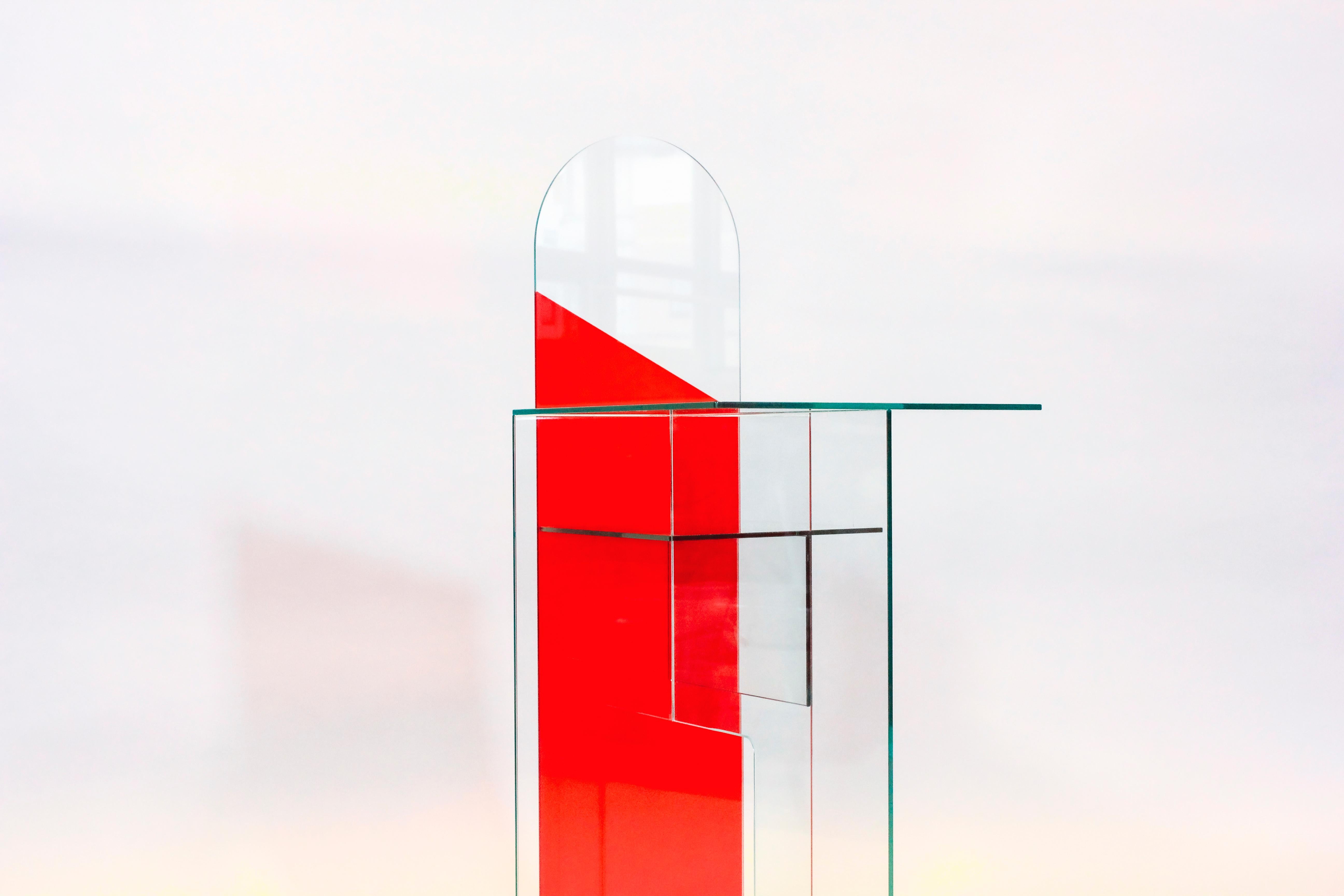 Mirrored glass contemporary Elaps table by Jan Farn Chi
Dimensions: L 686mm, W 480mm, H 1100mm
Material: 6mm toughened glass, 6mm mirrored glass. Tint film

Elaps’ is a glass centrepiece table that evolves with the changing daylight, thanks to